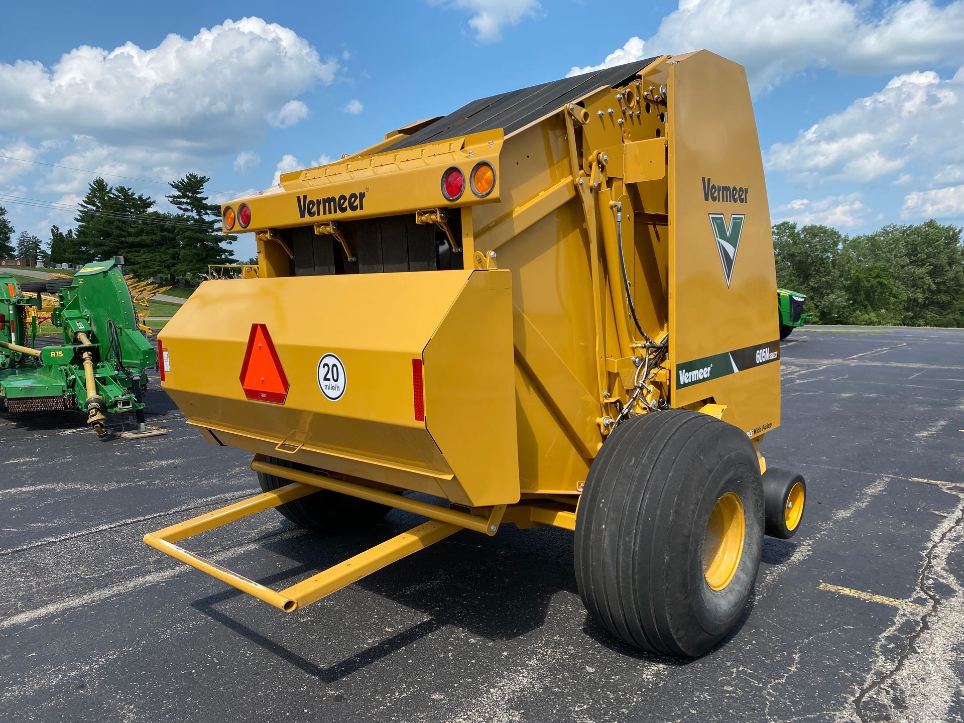 Yellow Vermeer round baler on a paved lot on a sunny day.