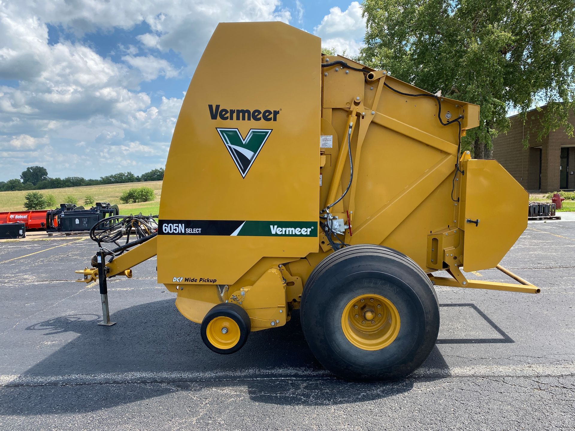 Yellow Vermeer baler on asphalt, side view shot.
