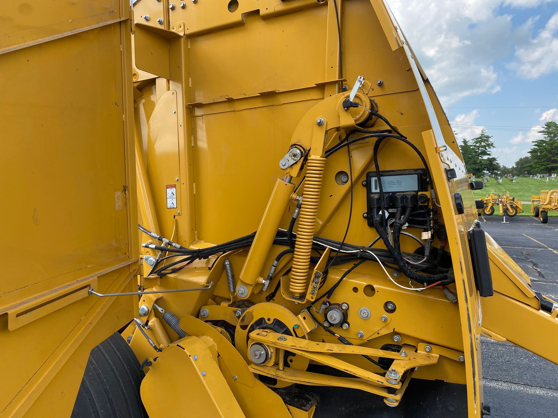 Yellow baler interior with belts, chains, and mechanical components, another angle shot.