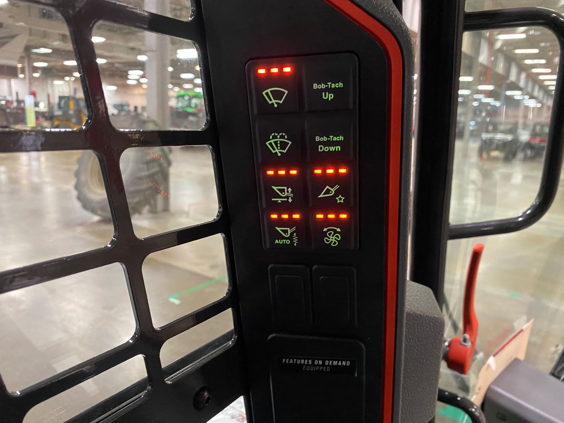 Control panel with illuminated icons and switches inside a heavy machine cab.
