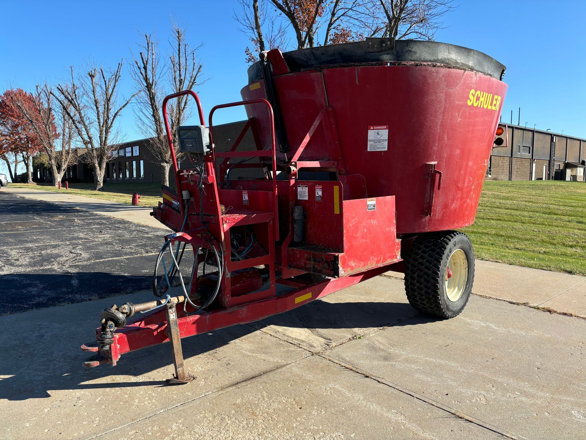 Red mixer trailer on pavement.