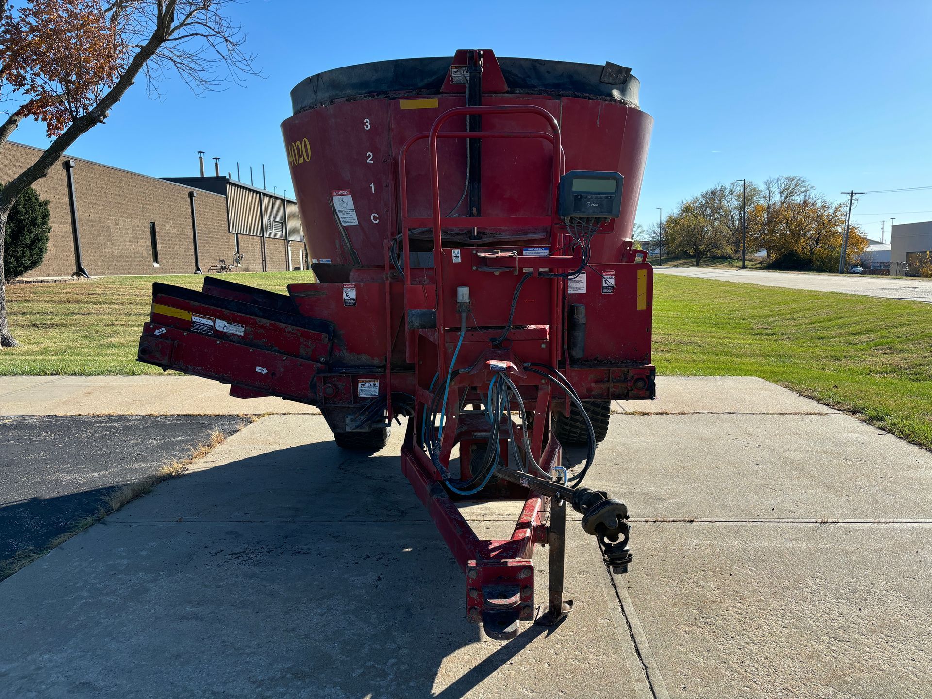 Red mixer trailer on pavement, front shot.