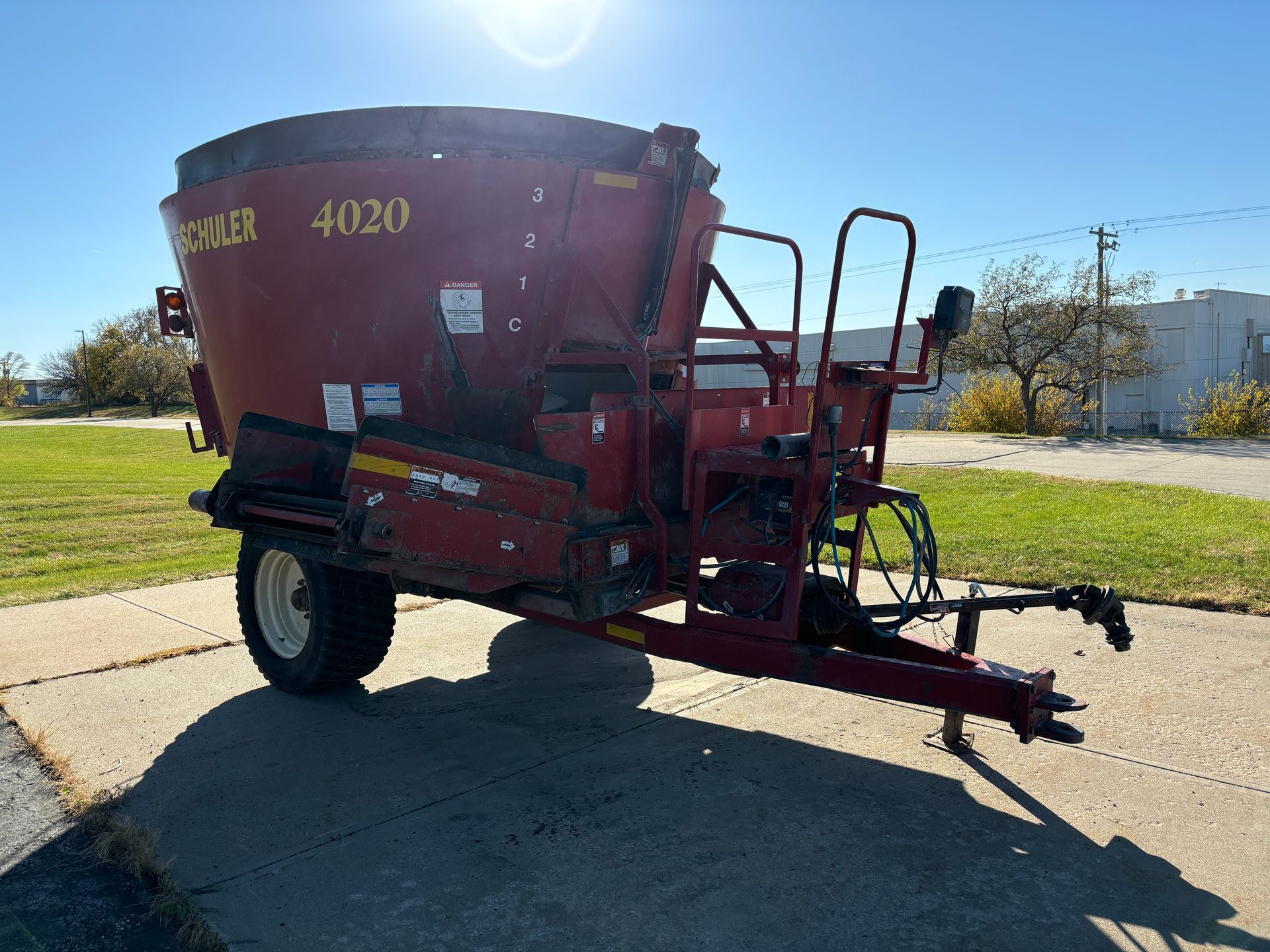 Red mixer trailer on pavement, front angled shot.