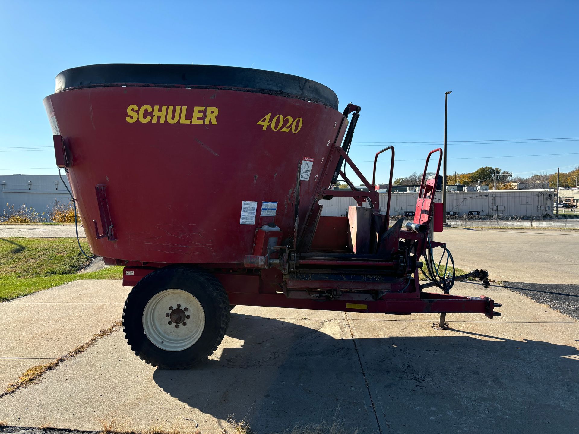 Red mixer trailer on pavement, side view shot.