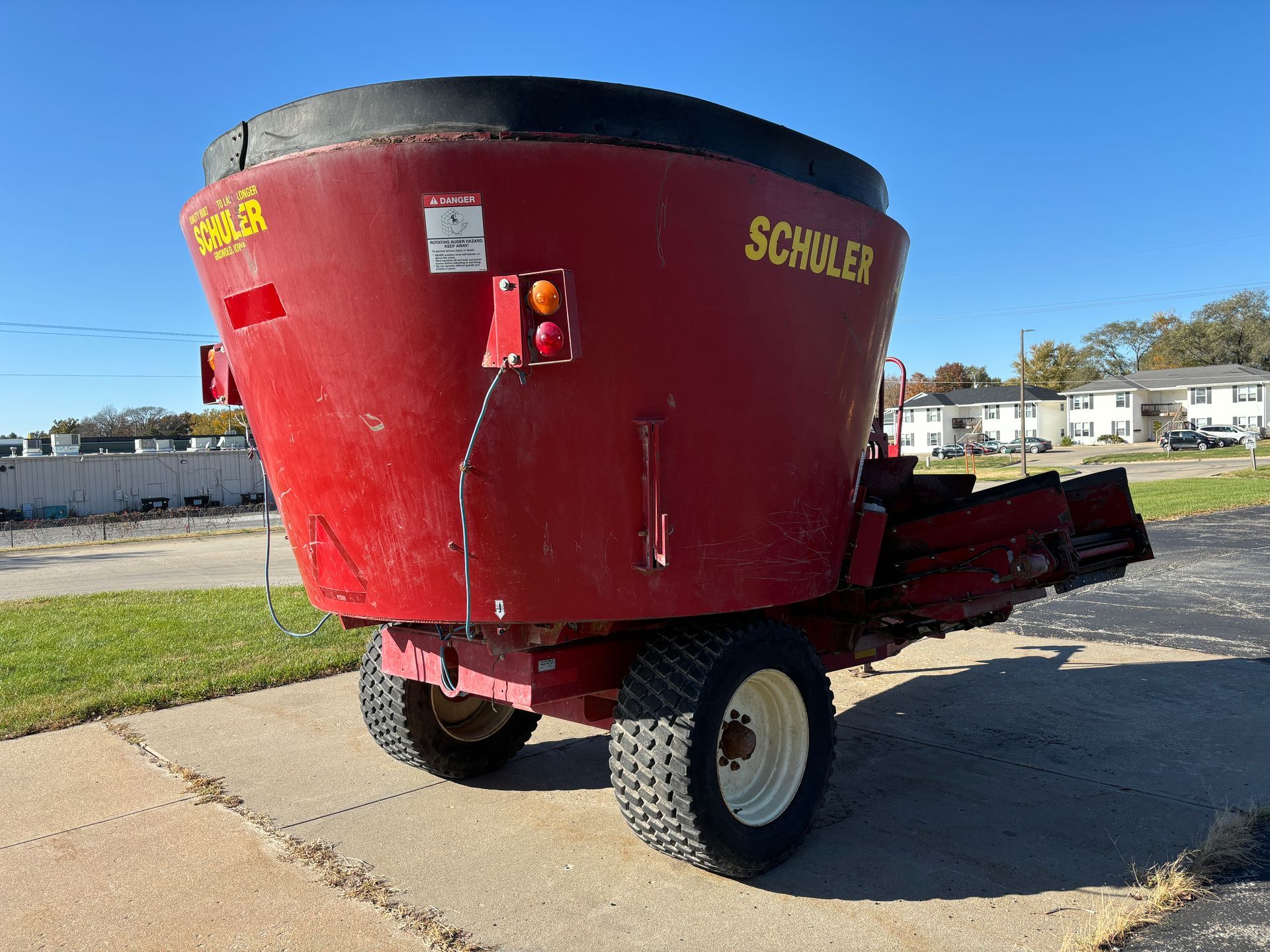 Red mixer trailer on pavement, back angled shot.