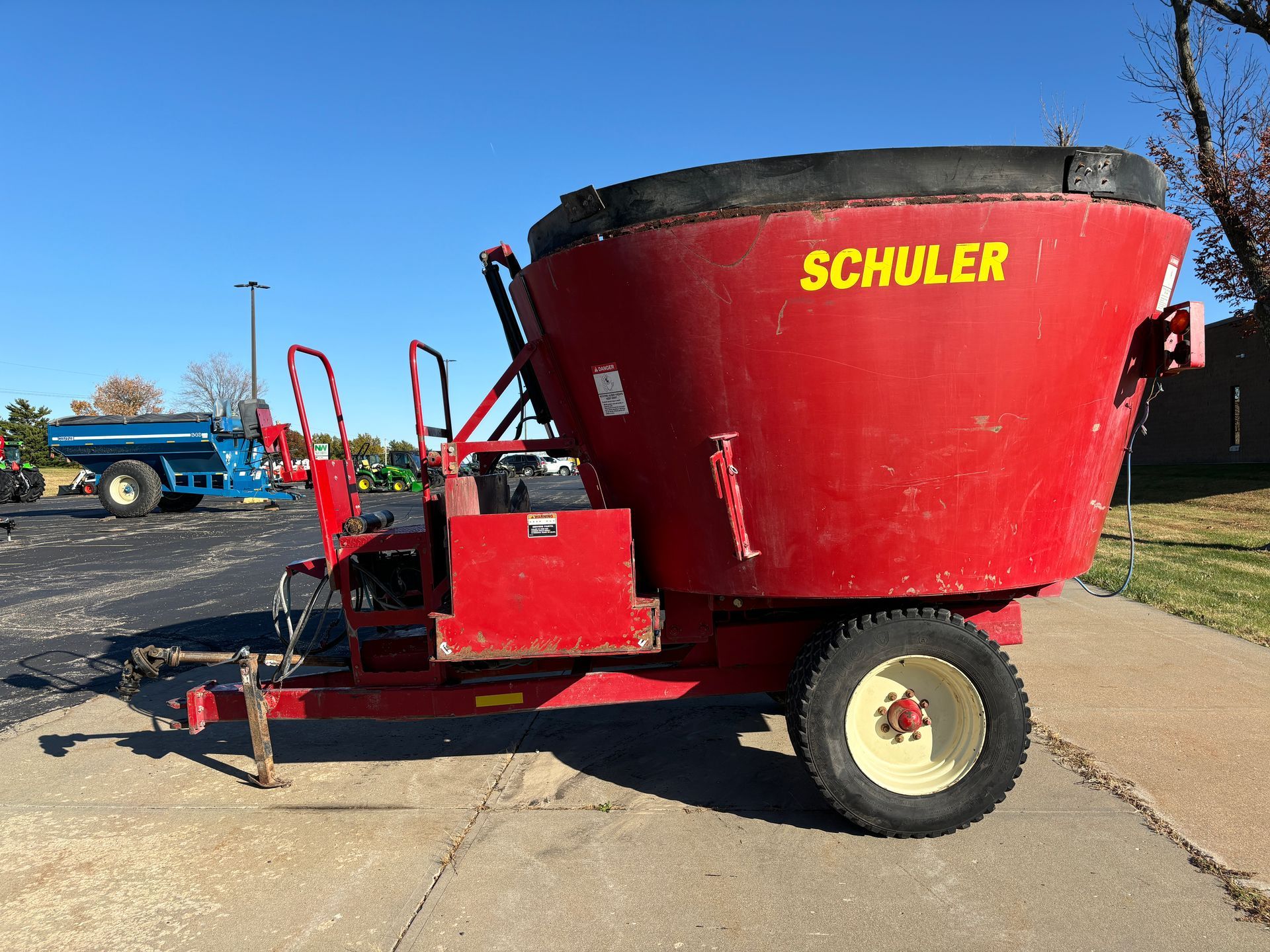 Red mixer wagon on pavement, side view shot.