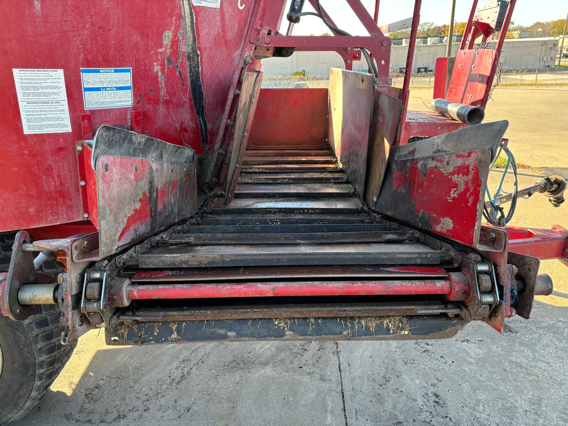 Red mixer wagon with a conveyor belt.