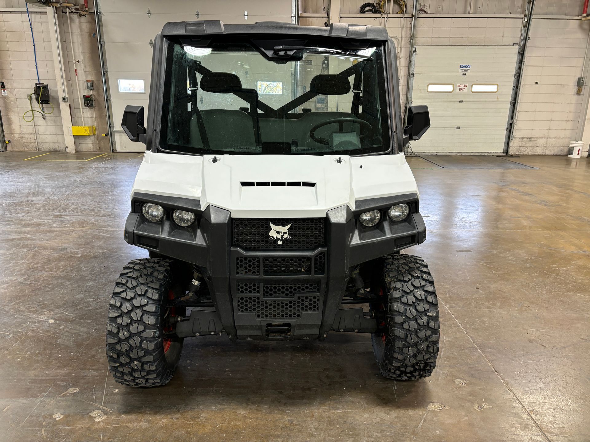 White Bobcat UTV with black accents, parked indoors. Front view.