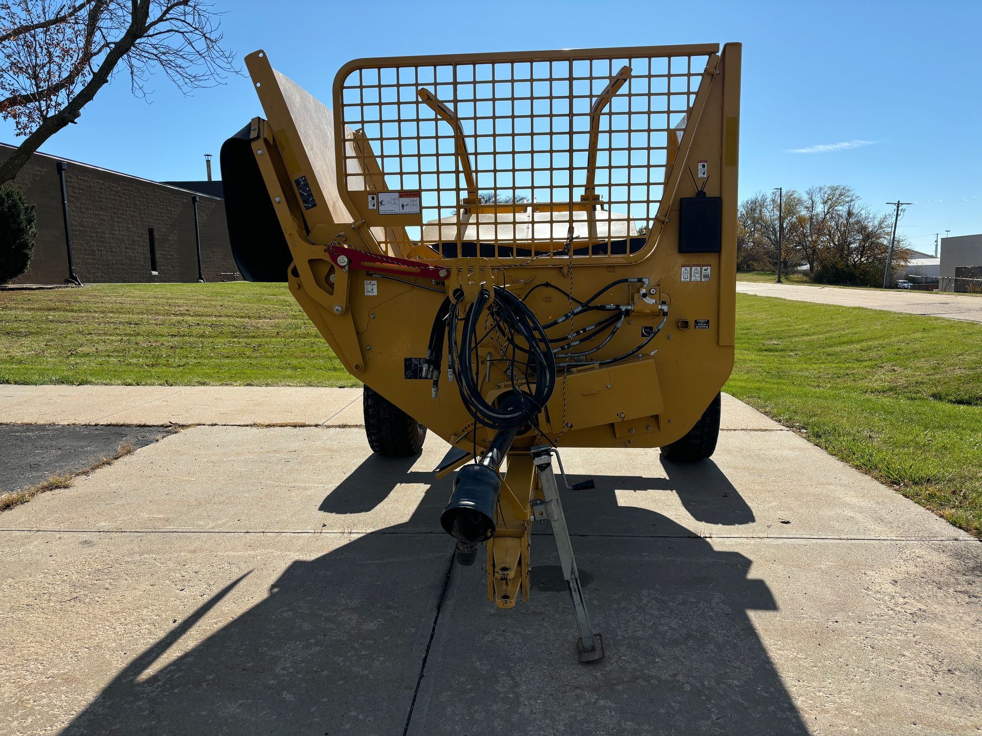 Yellow bale processor on a paved surface, front shot.