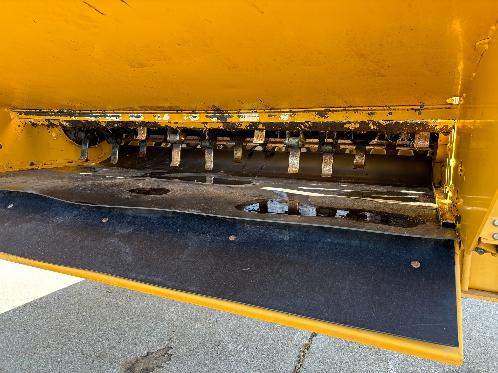Yellow bale processor with a black rubber bottom and metal teeth.