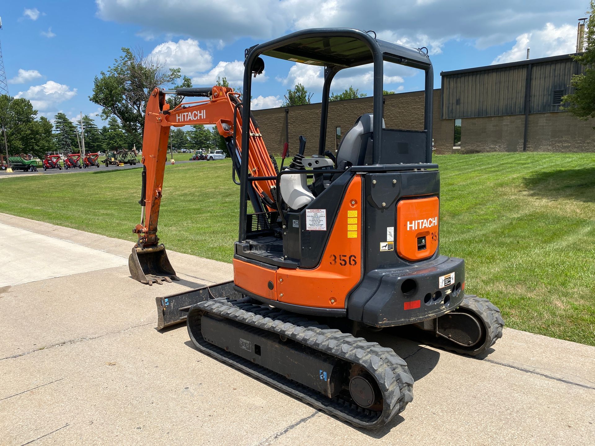 Orange and black Hitachi 35B mini excavator on a paved surface, outdoors.