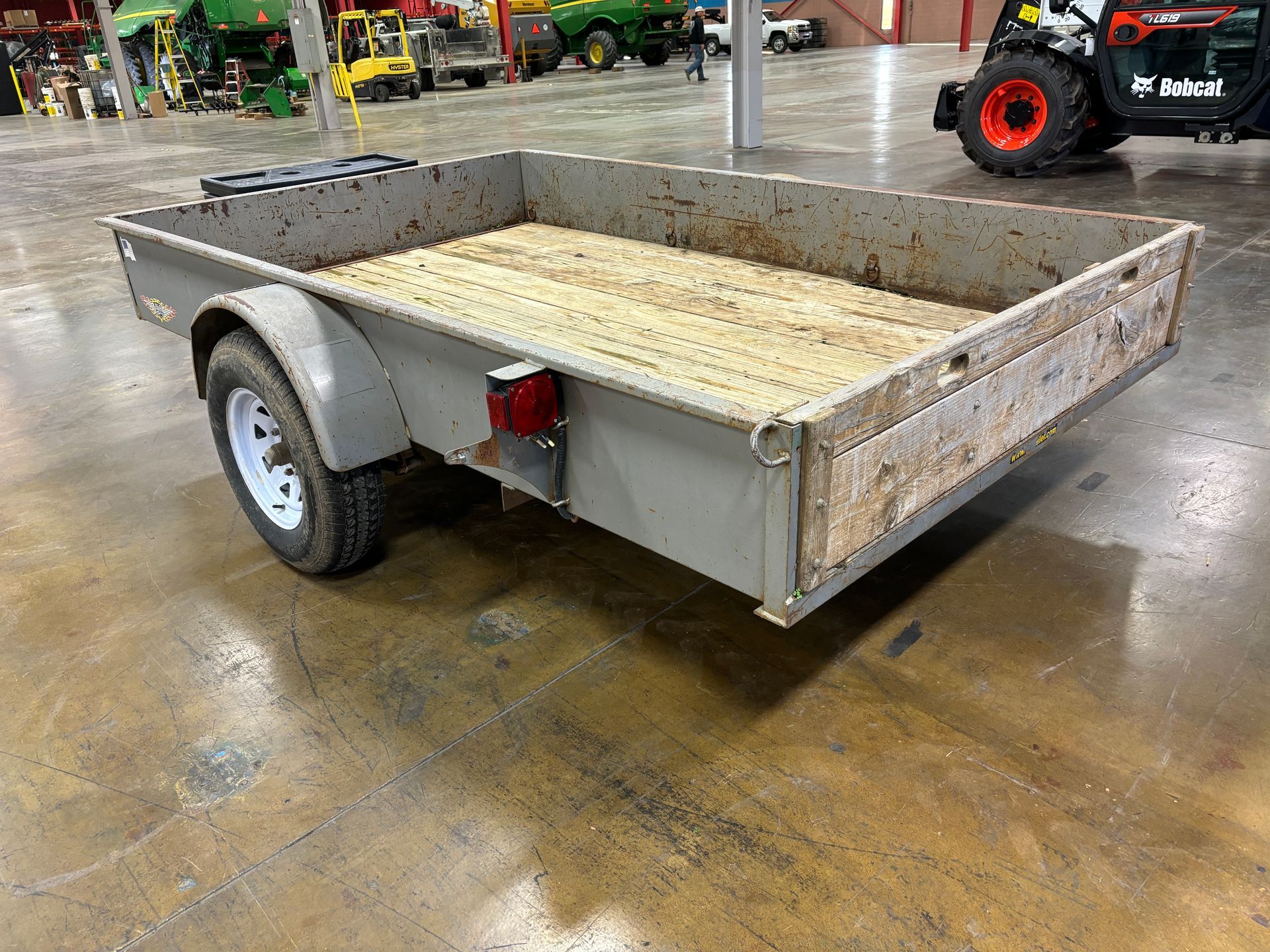 Flatbed trailer with wooden floor, in a large warehouse.