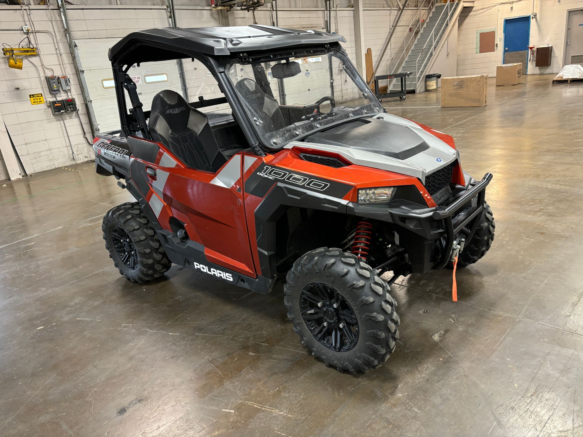 Red Polaris General side-by-side ATV on a warehouse floor.