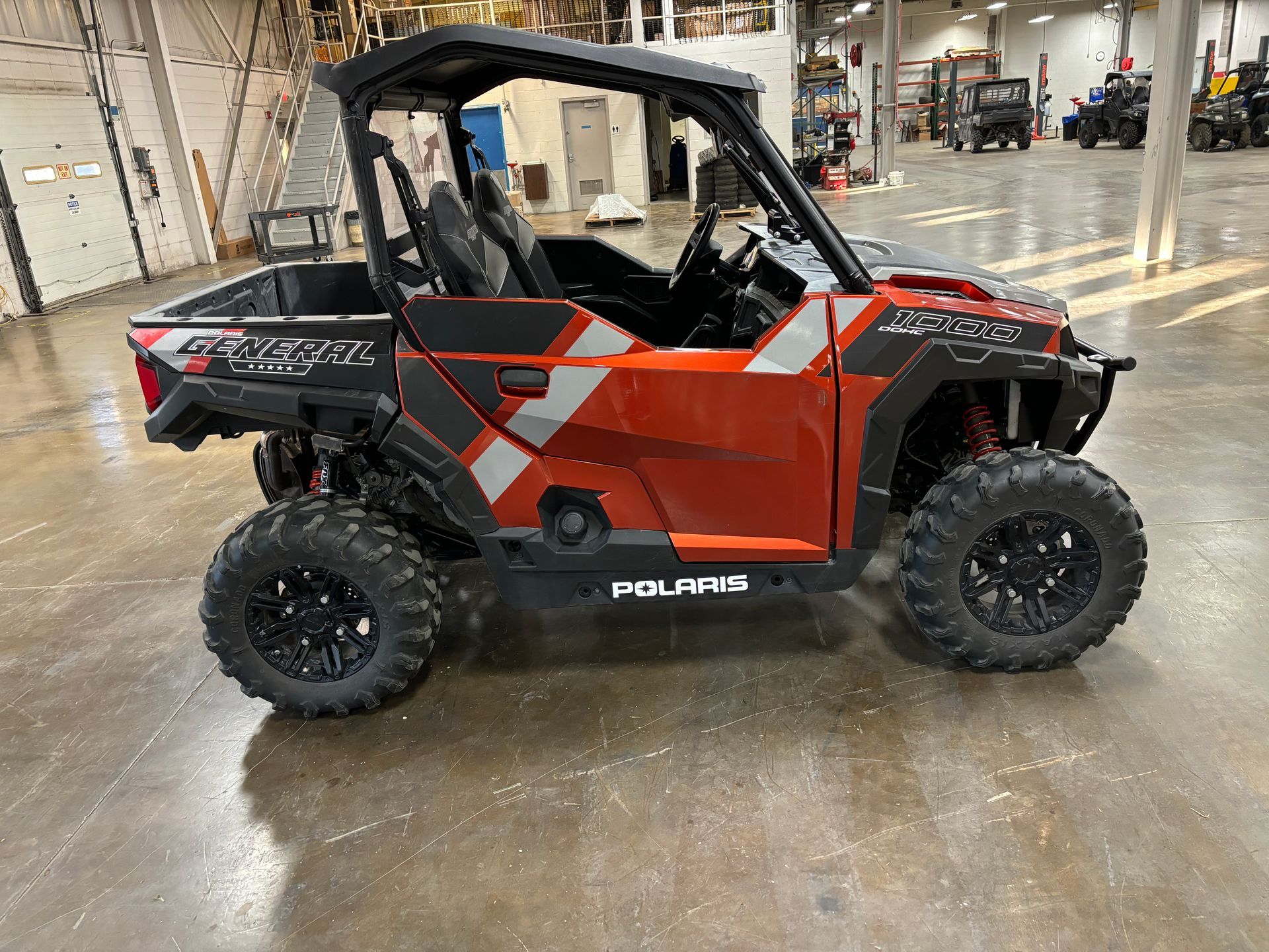 Orange and gray Polaris General UTV in a warehouse.