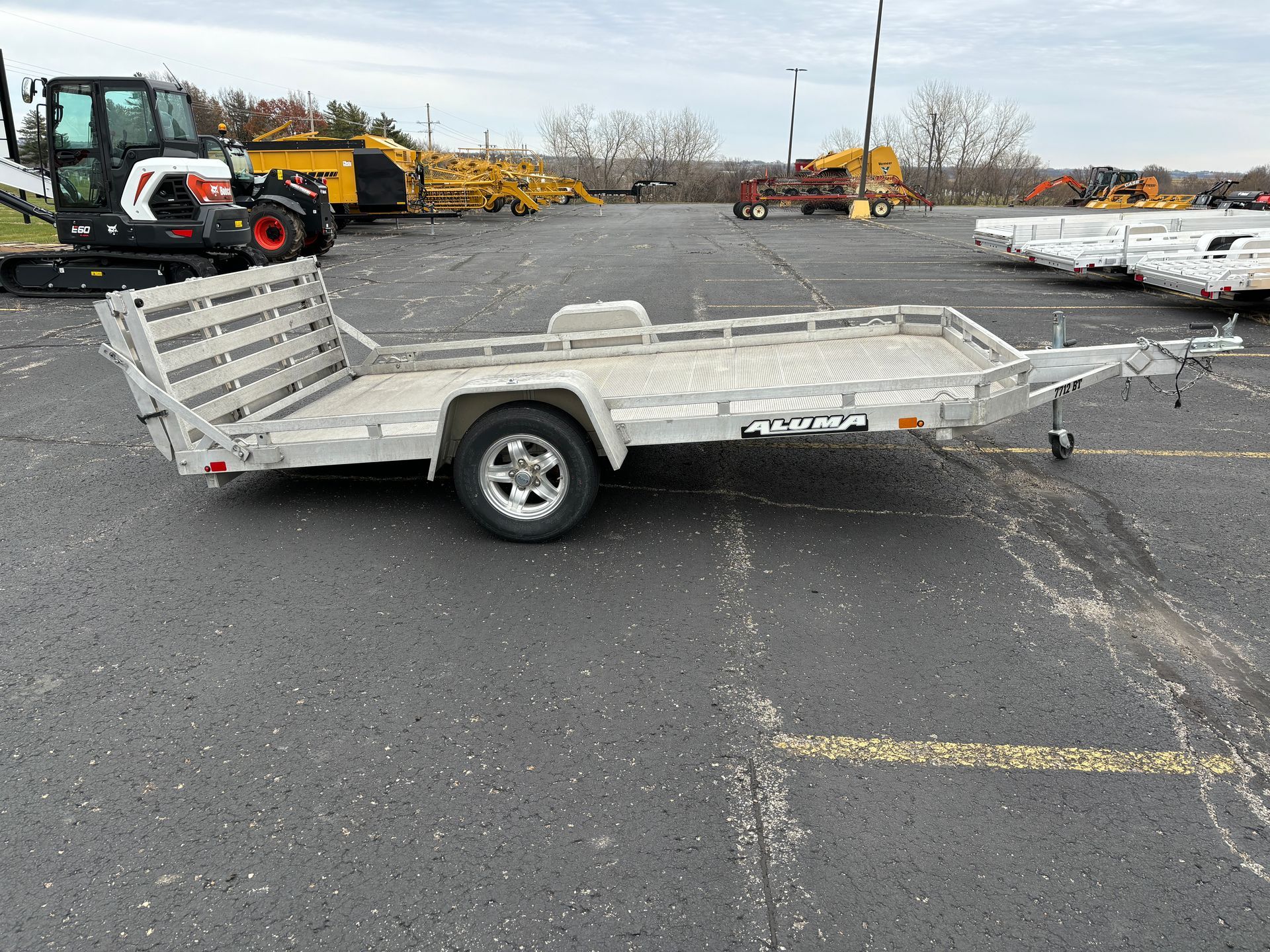 Aluminum utility trailer parked on asphalt.