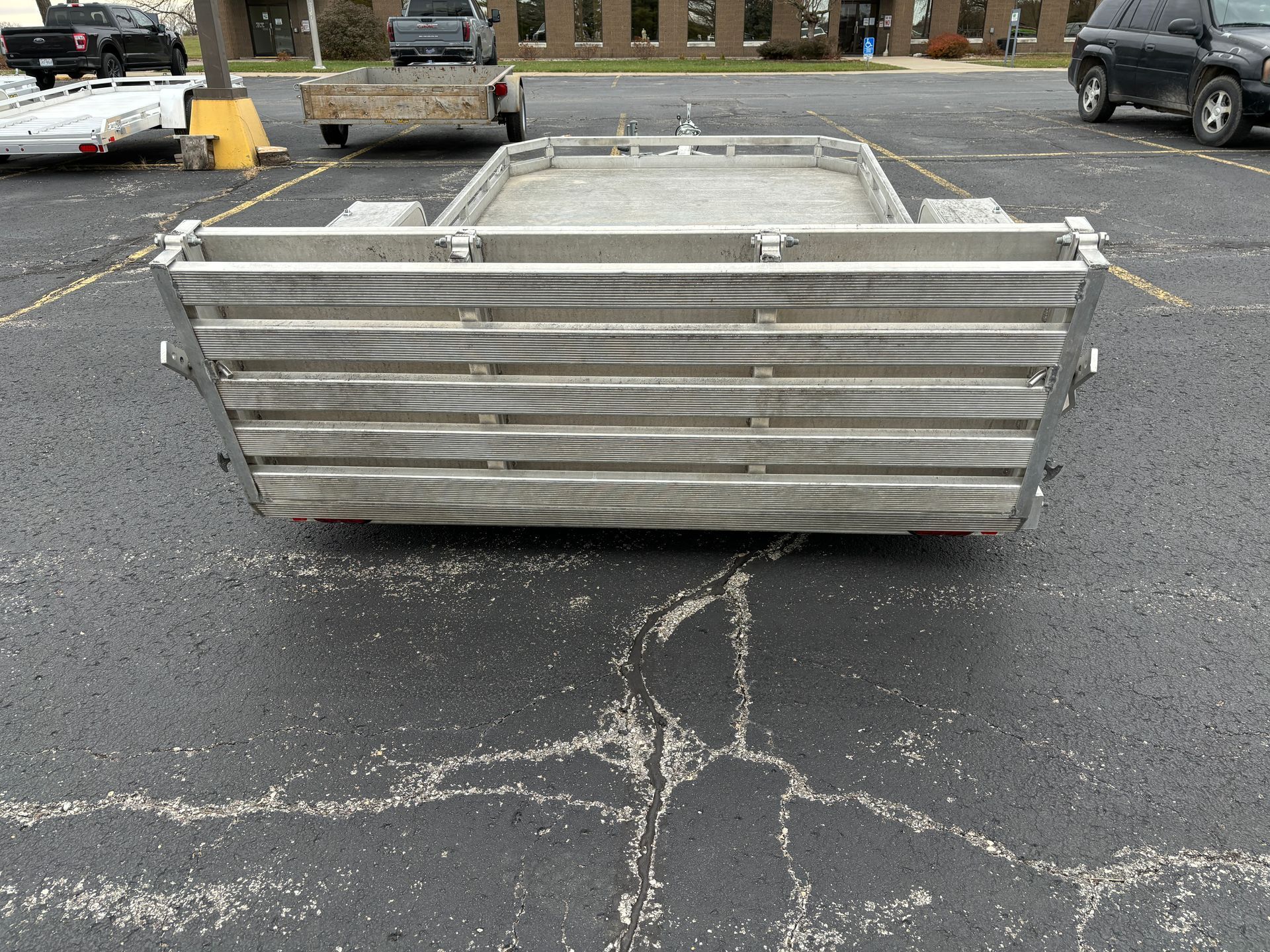 Silver metal trailer bed in a parking lot.