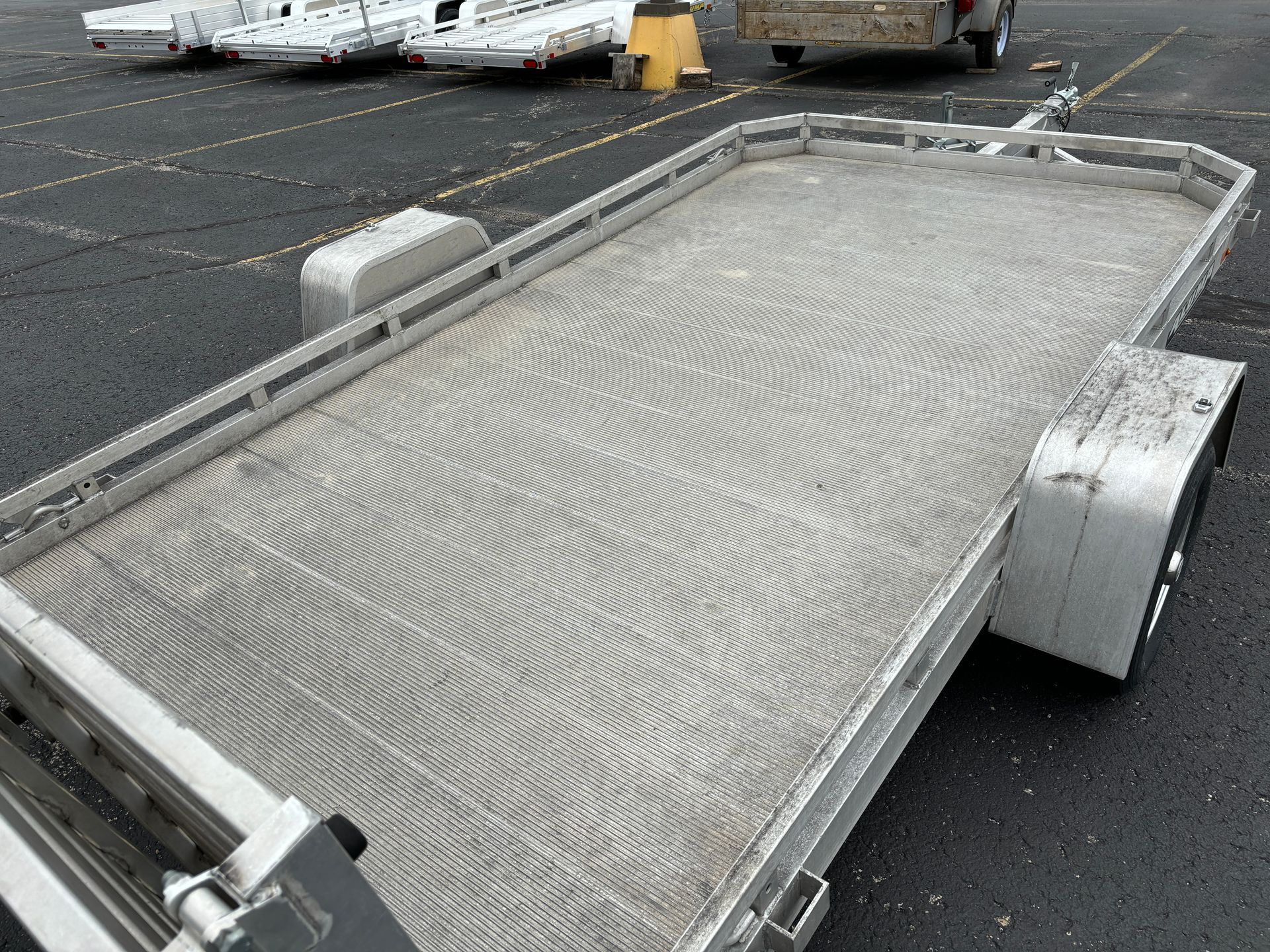 Aluminum utility trailer on a paved surface.