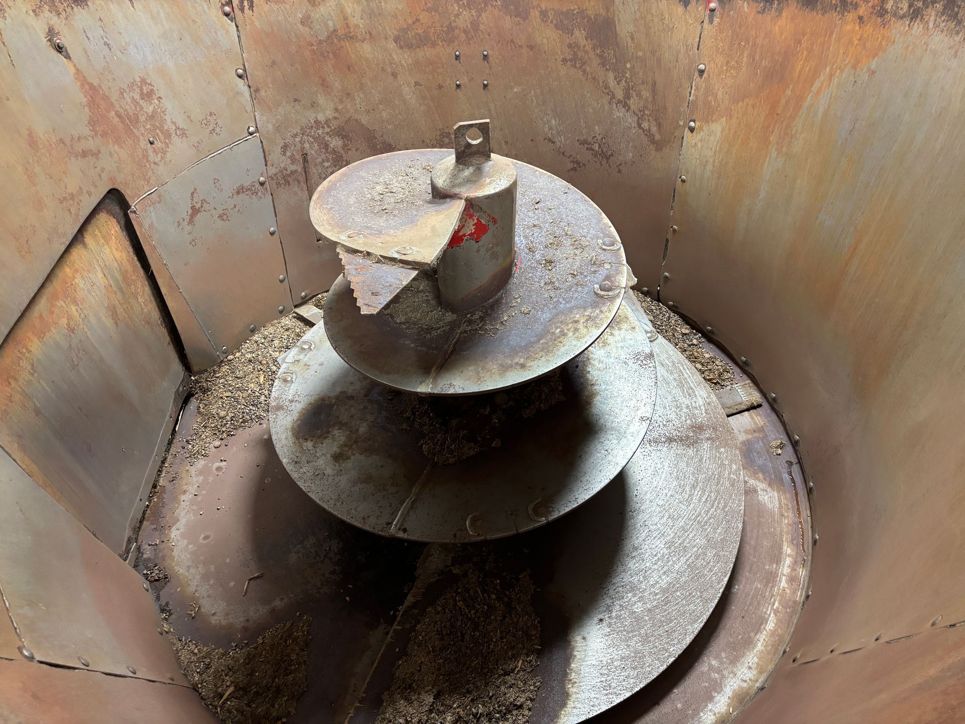 Inside view of a metal mixer wagon with a large screw auger.