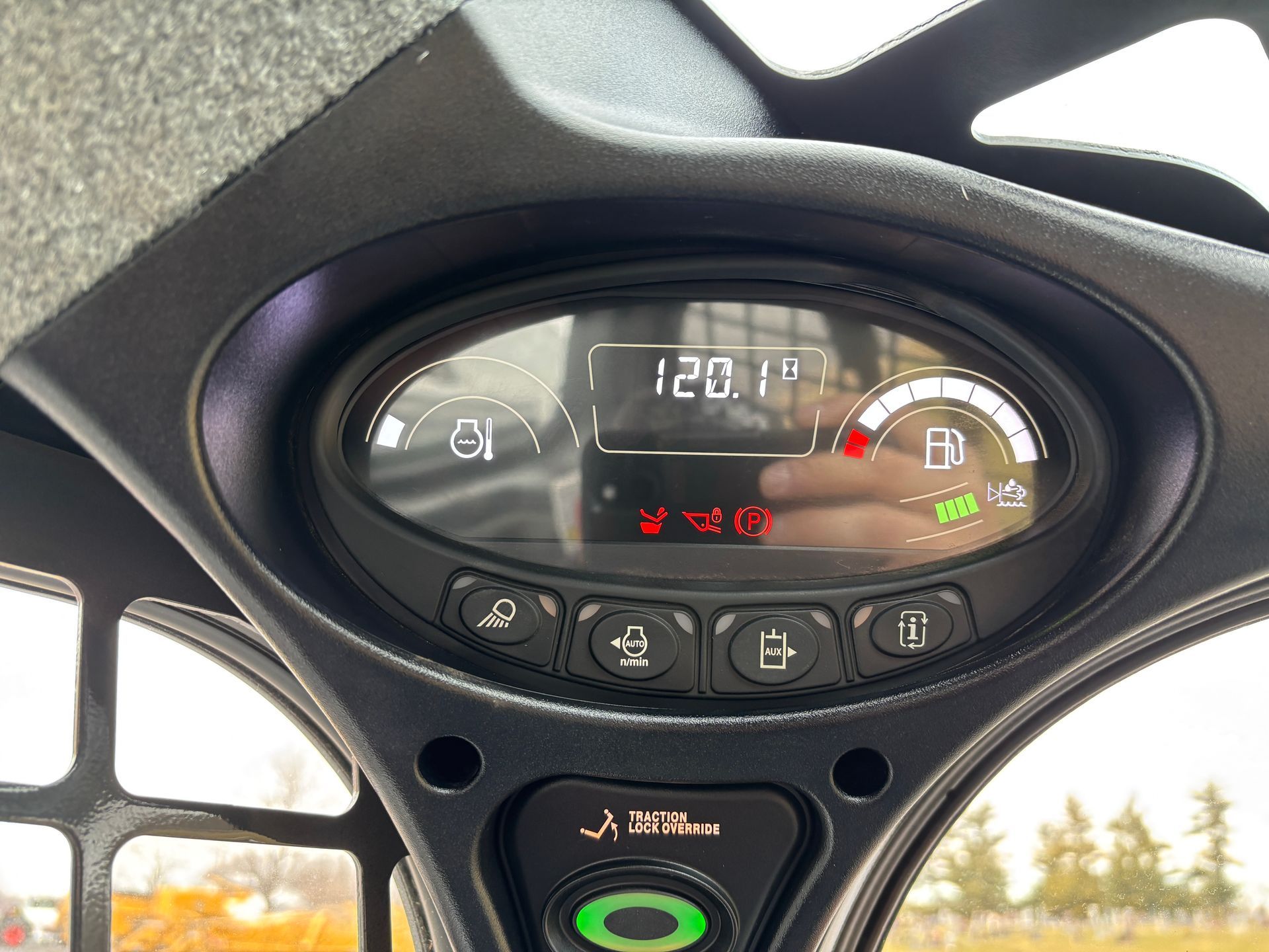 Dashboard of a Bobcat compact track loader showing gauges and warning lights, with a temperature reading of 120.1°F.
