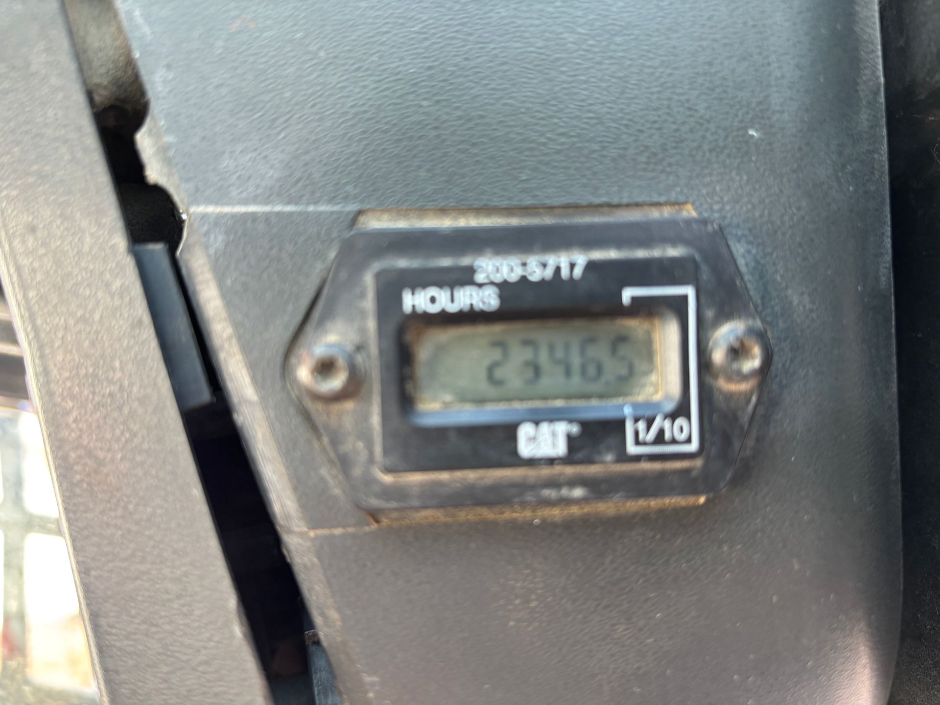 Hour meter showing 2346.5 hours on a Caterpillar machine, mounted on a black surface.