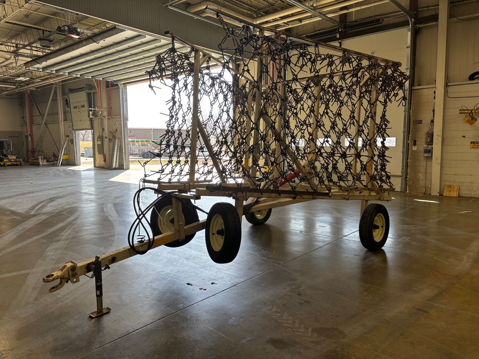 A trailer with a large, net-covered frame in a warehouse.