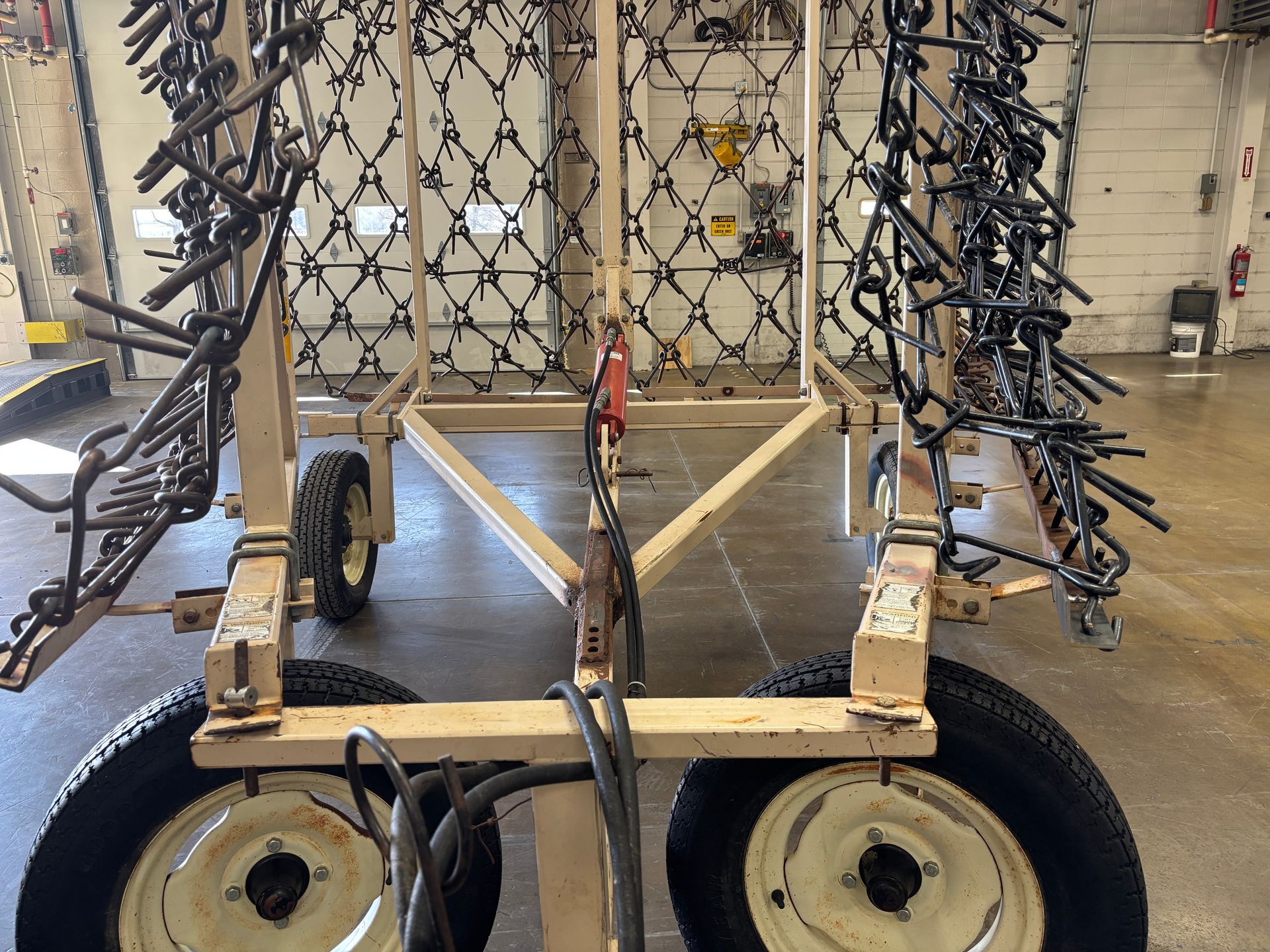 Farm implement with a wheel assembly, metal tines.