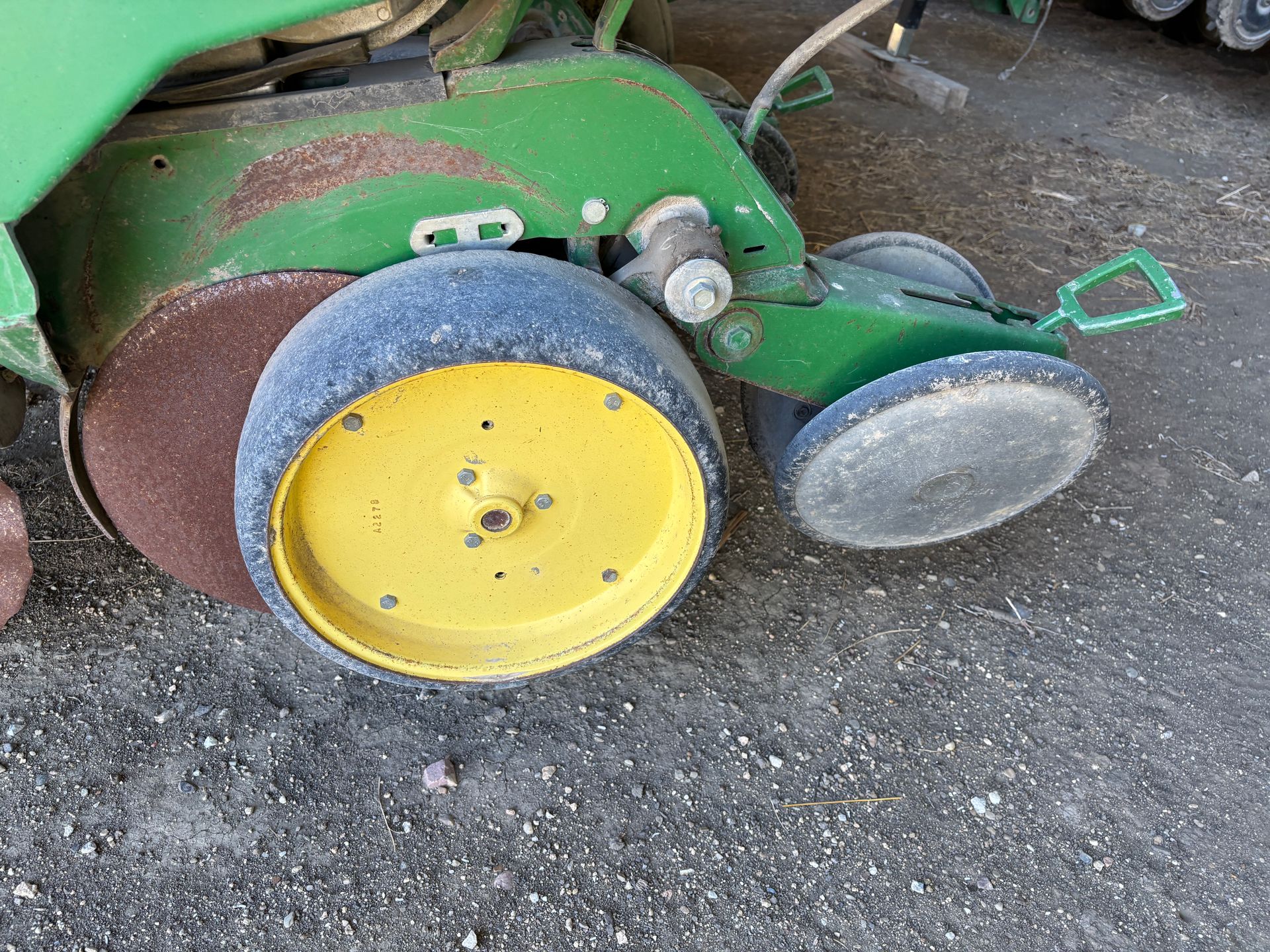 Close-up of a John Deere planter wheel. Green metal and yellow and blue tires are visible.