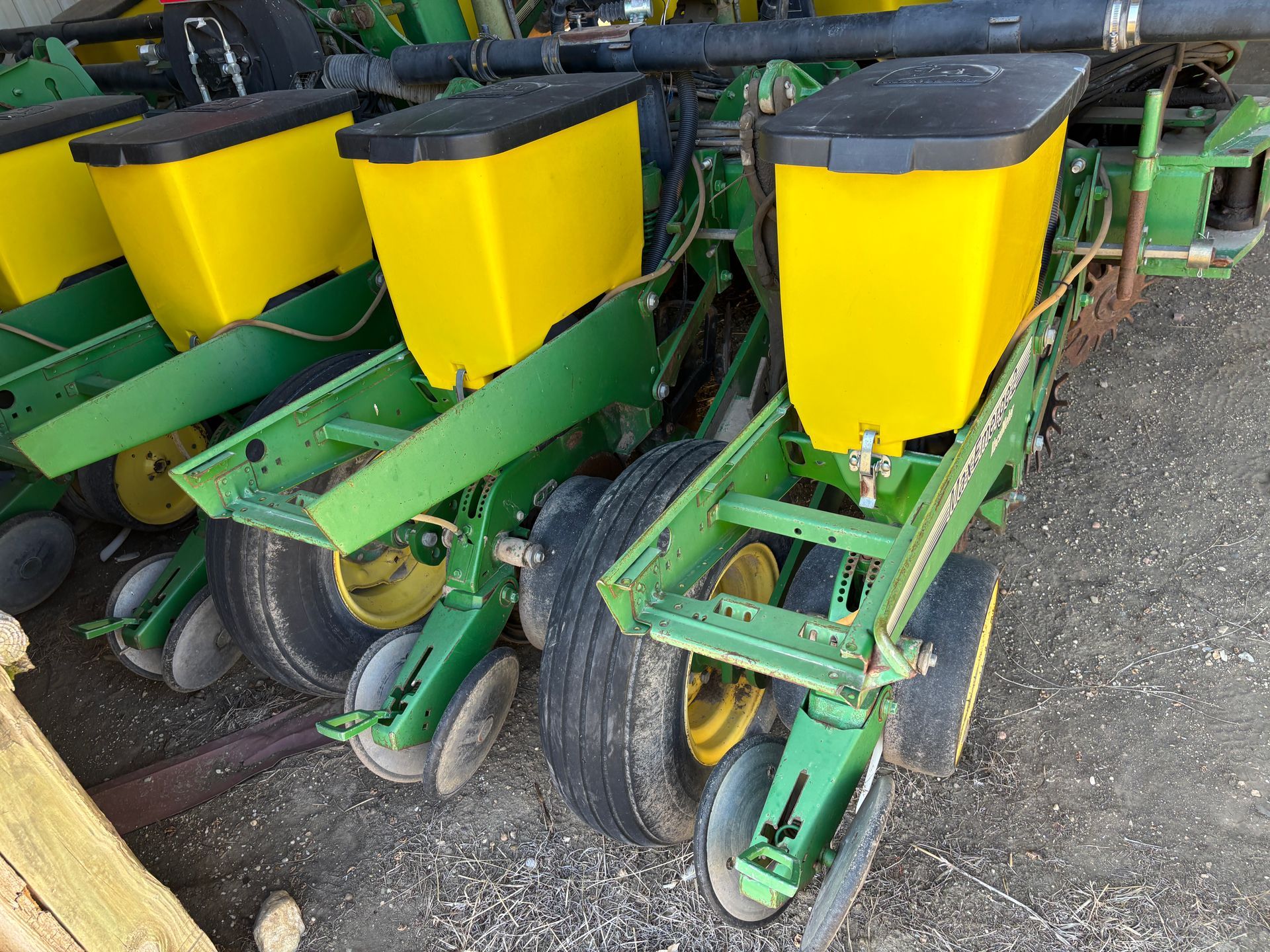 John Deere row crop planter with yellow hoppers and green frame.