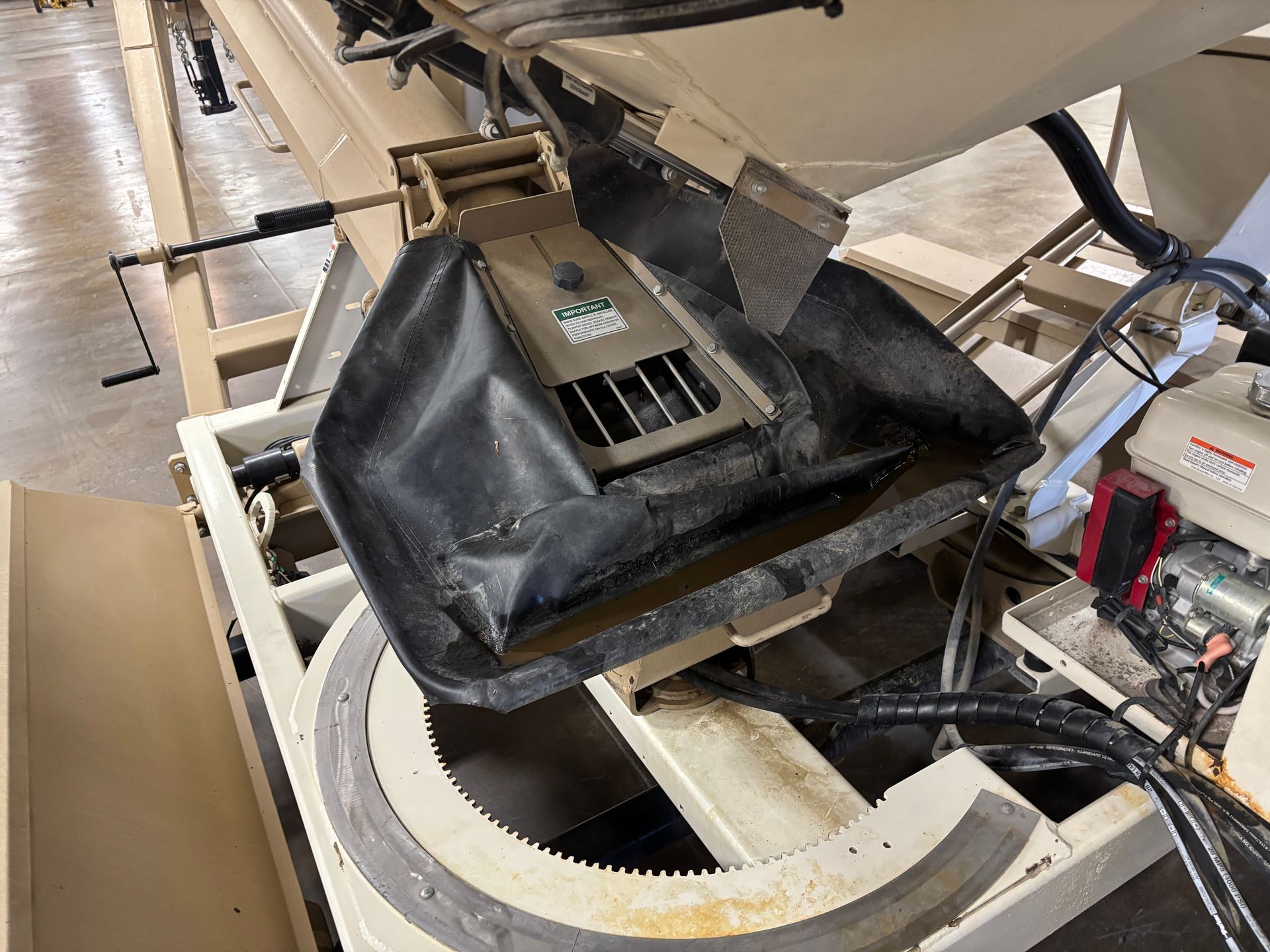An industrial machine with a conveyor belt and hopper. Beige and black components.