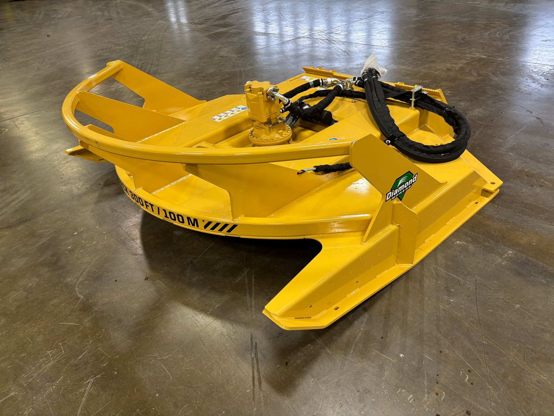 Yellow brush cutter for tractor, with hydraulic hoses.