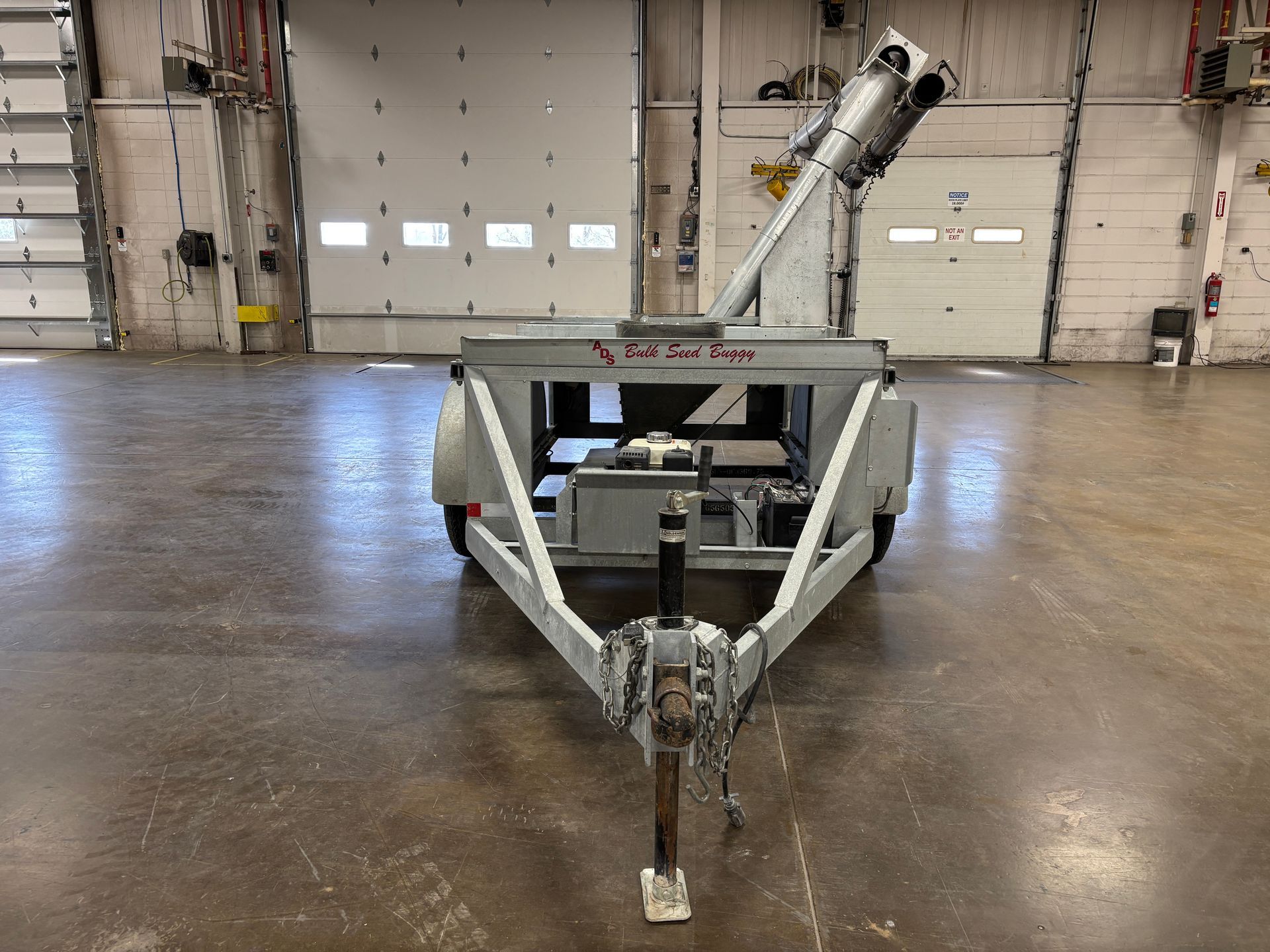 Gray industrial trailer with an angled conveyor in a warehouse.