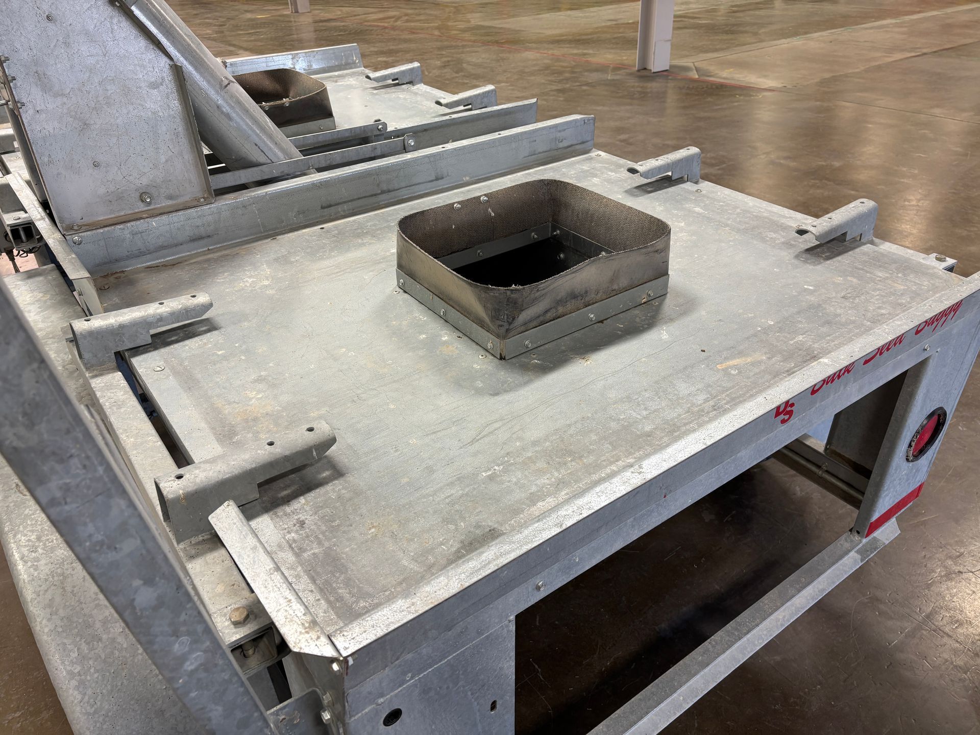 Flatbed truck body with a central opening. Metal construction in a warehouse.