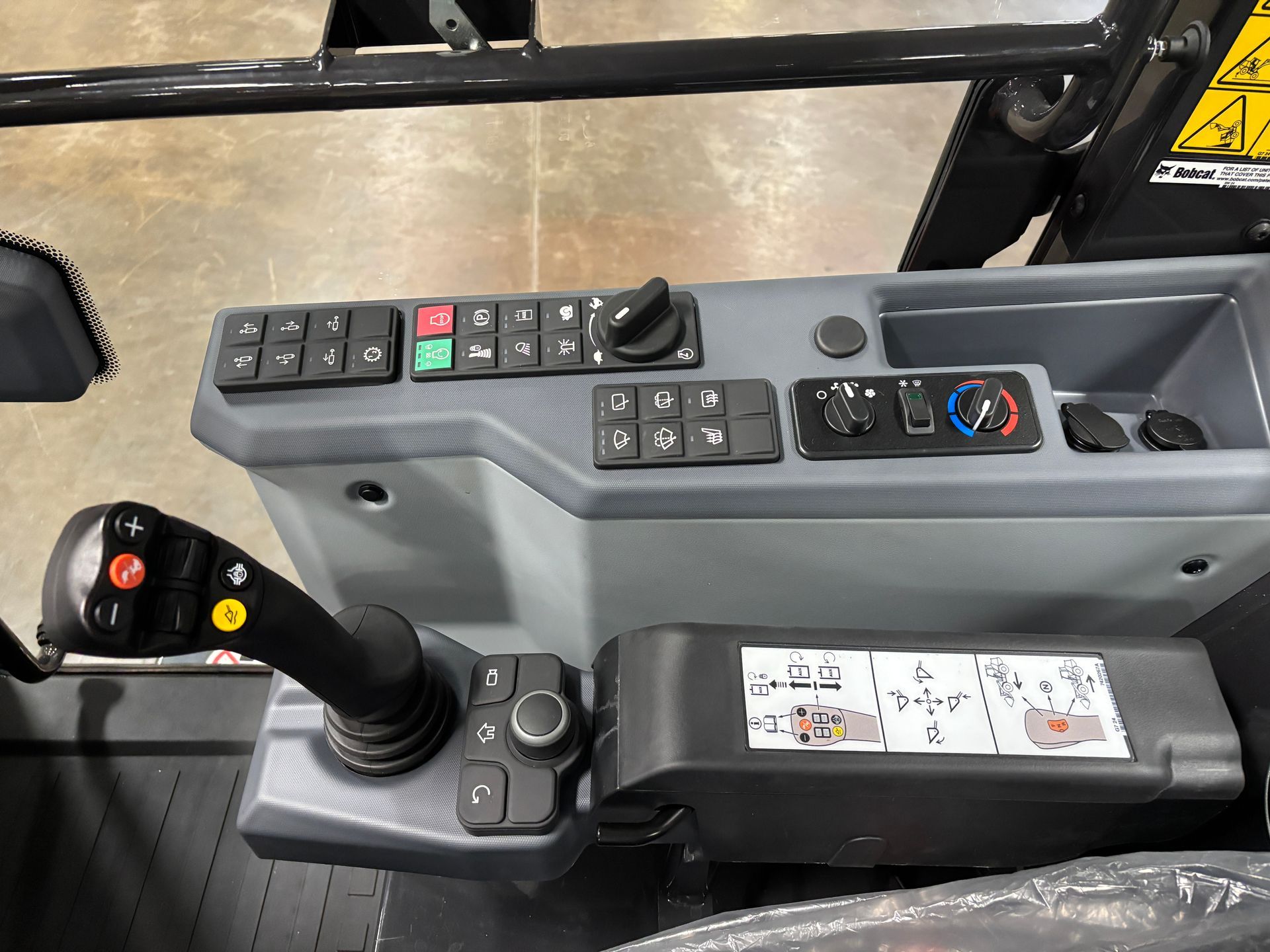 Control panel of heavy machinery. Includes joystick, buttons, and dials. Gray and black.