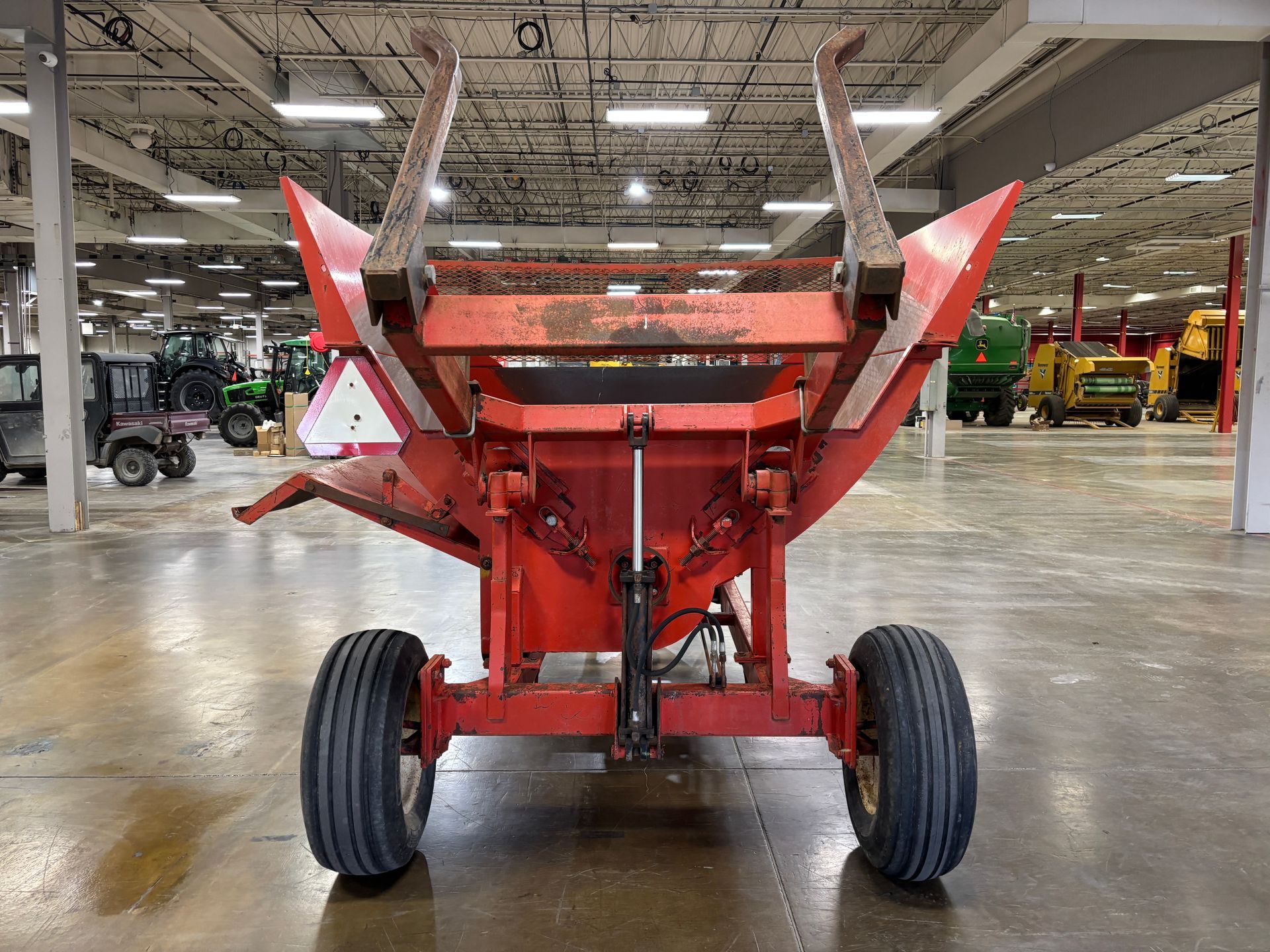 Red Highline bale processor on a trailer, in a warehouse, back shot.
