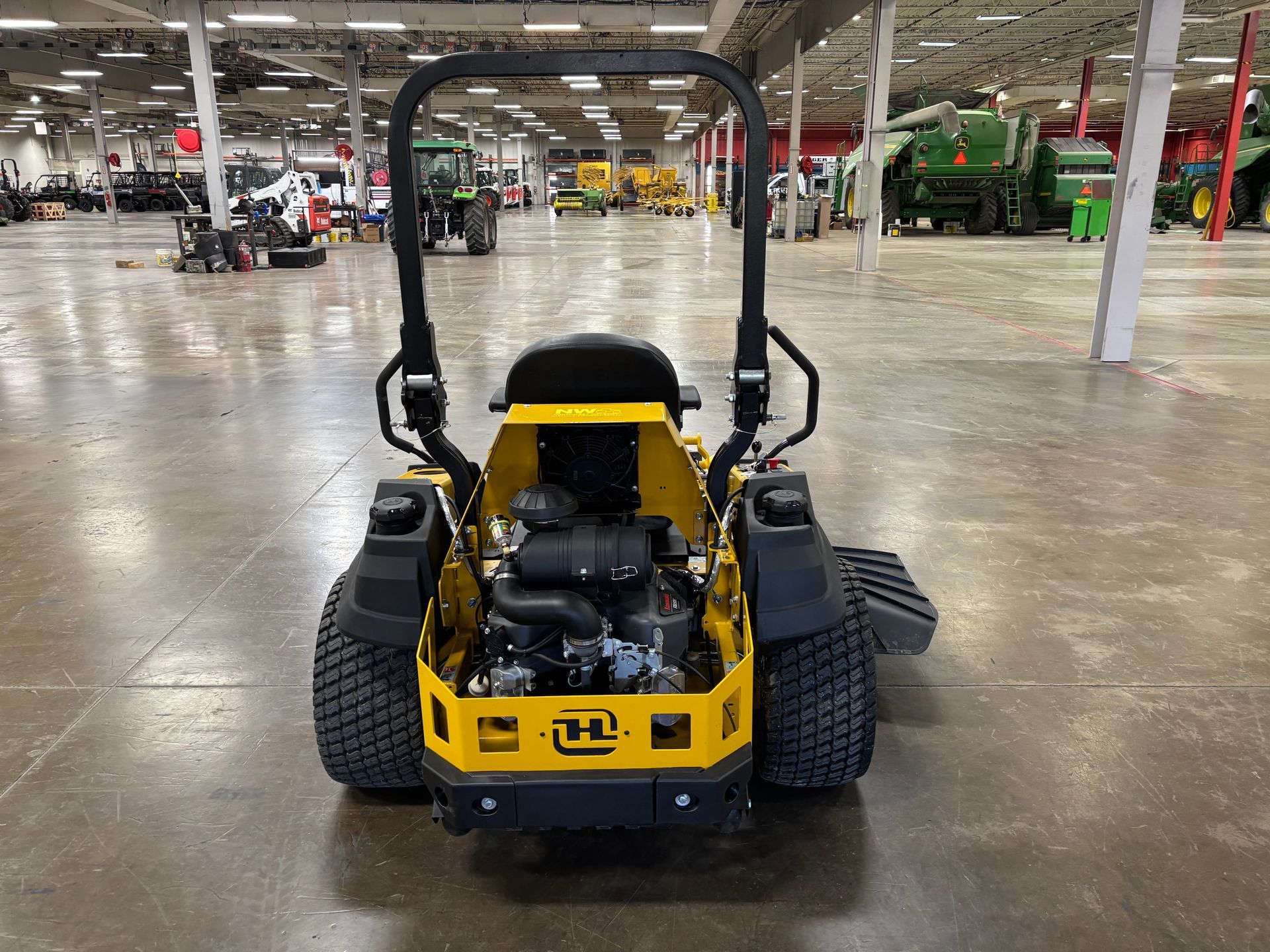 Yellow commercial zero-turn lawnmower on a concrete floor.