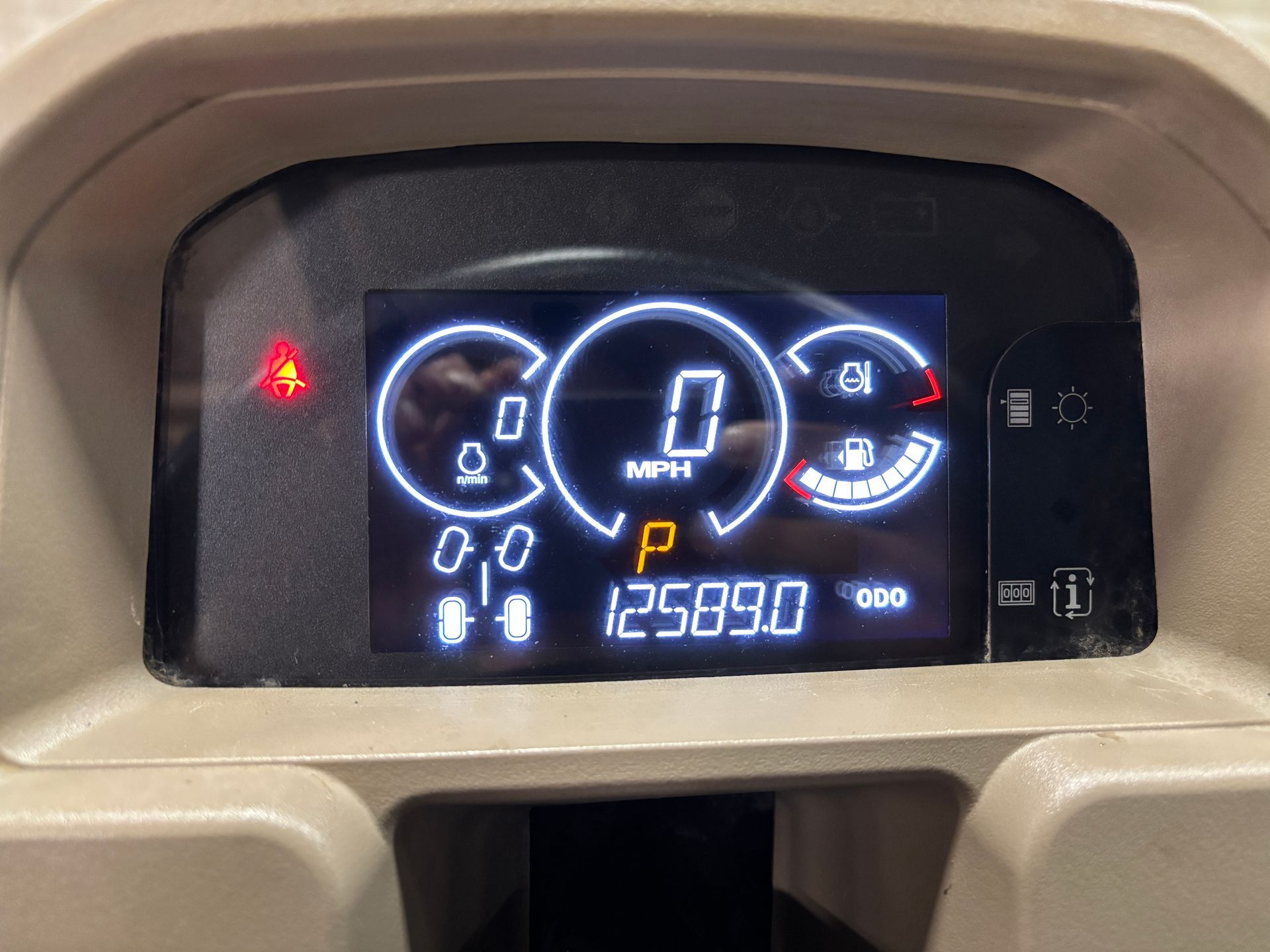 Dashboard displaying speed, fuel gauge, and warning lights; shows 0 MPH, 12589.0 miles.