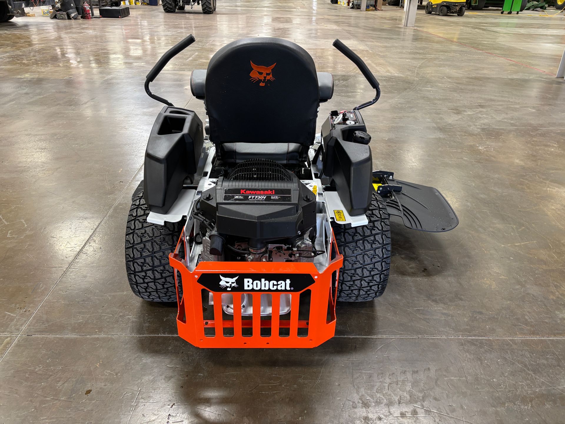 Bobcat zero-turn mower in a showroom, black and orange details, rugged tires.