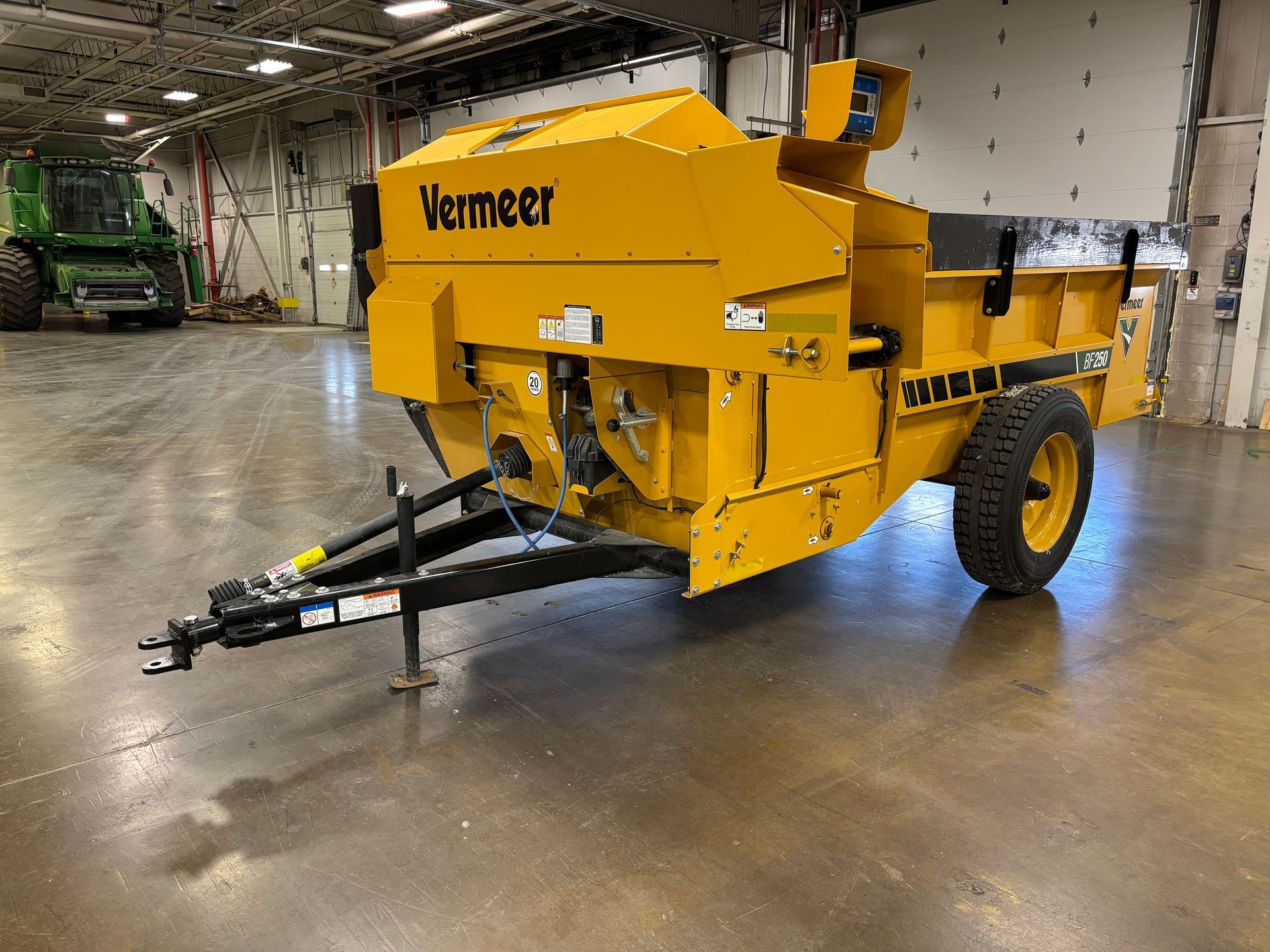 Yellow Vermeer stump grinder on wheels, indoors.