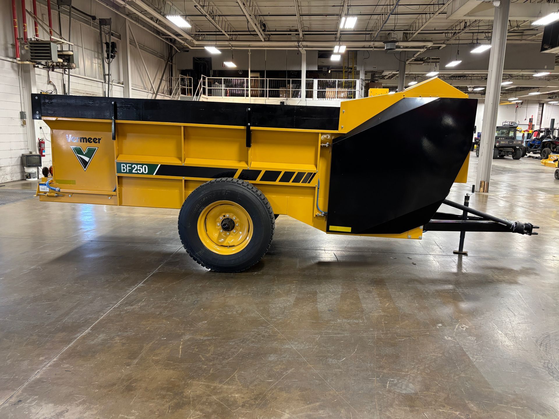 Yellow and black industrial trailer with a single tire, indoors.