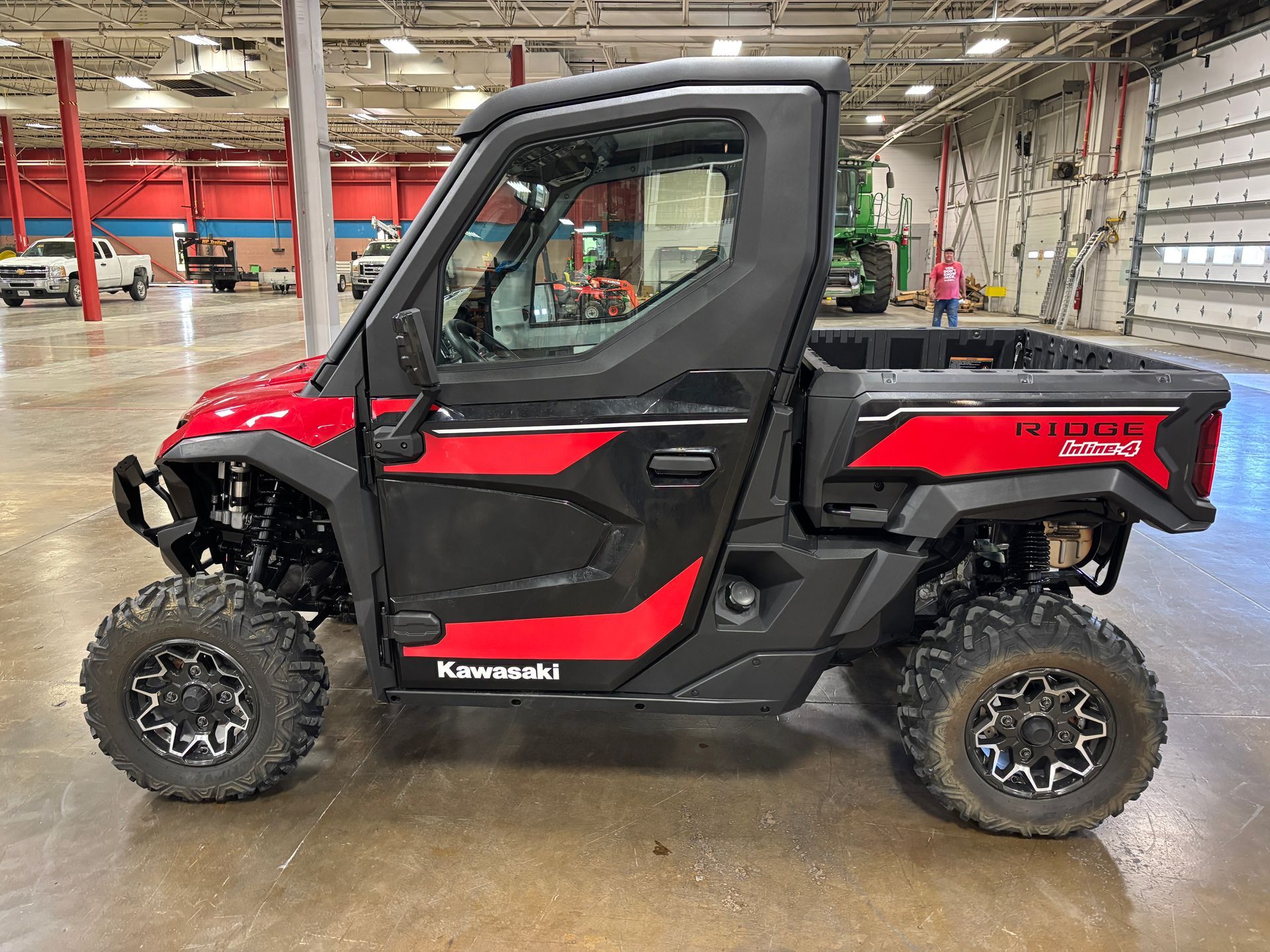 Red and black Kawasaki Teryx KRX side-by-side UTV with a black cab and black tires.