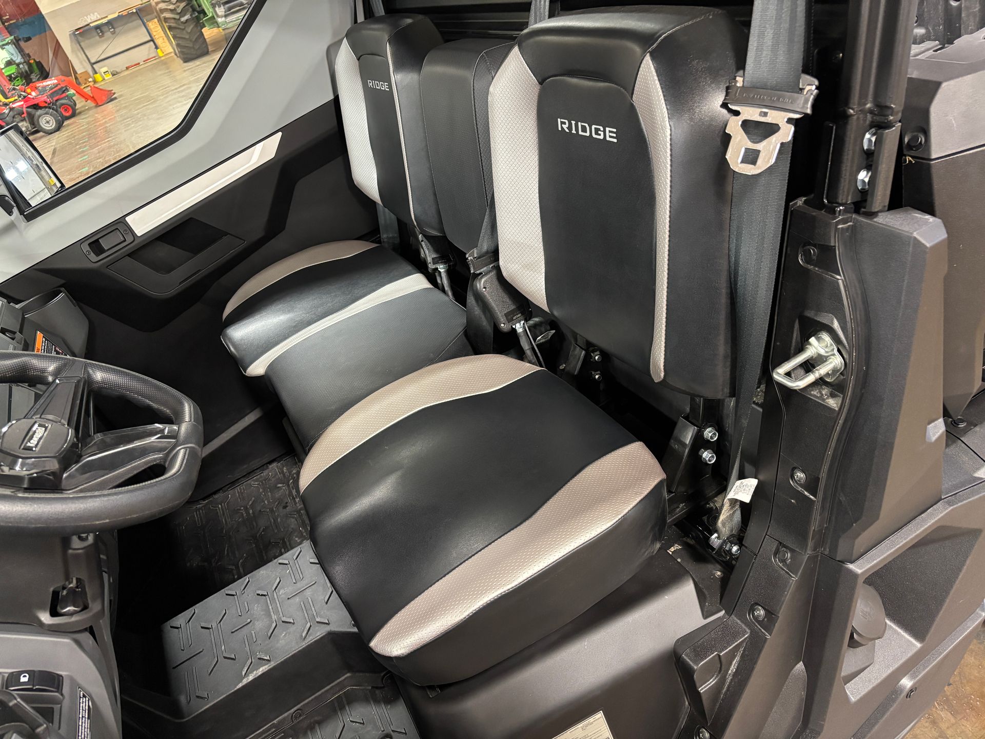 Black and gray UTV interior showing seats and steering wheel.