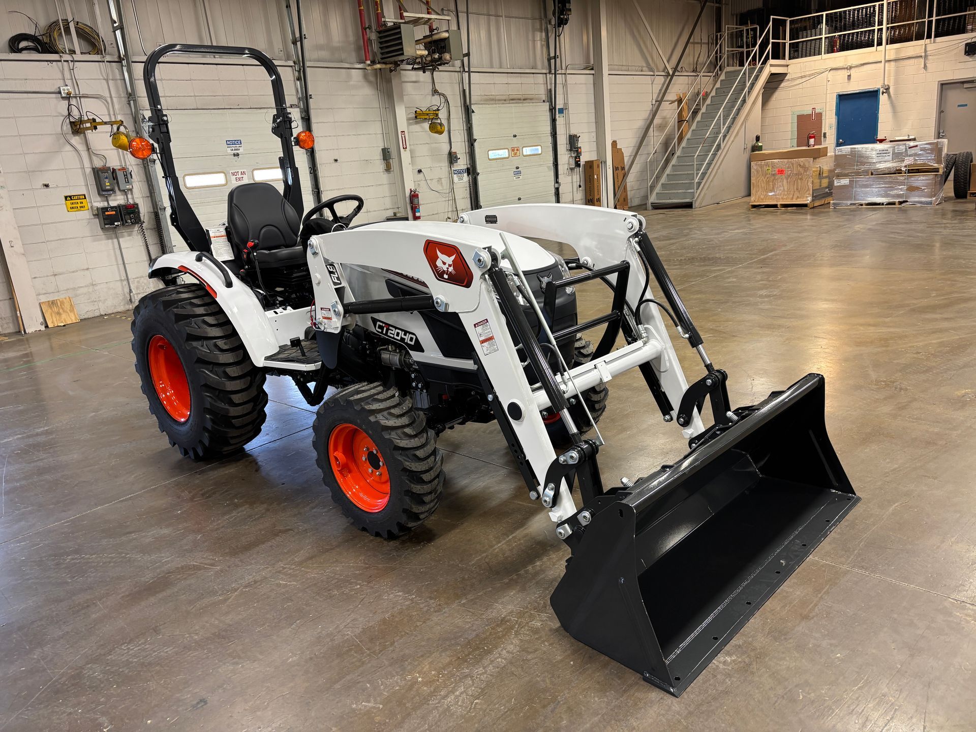 White Bobcat tractor with a front loader and orange wheels.