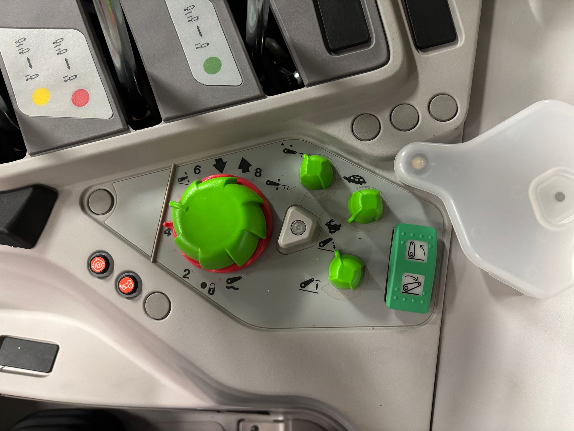 Control panel with green knobs and buttons on a gray surface, part of a machine.