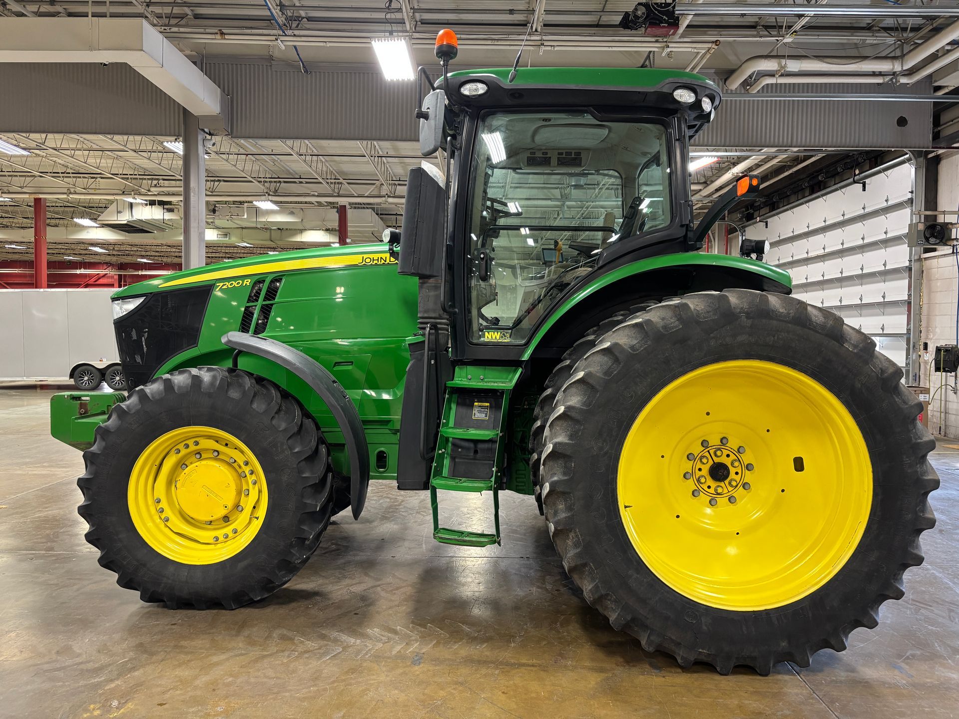 Green and yellow John Deere tractor parked inside a building.