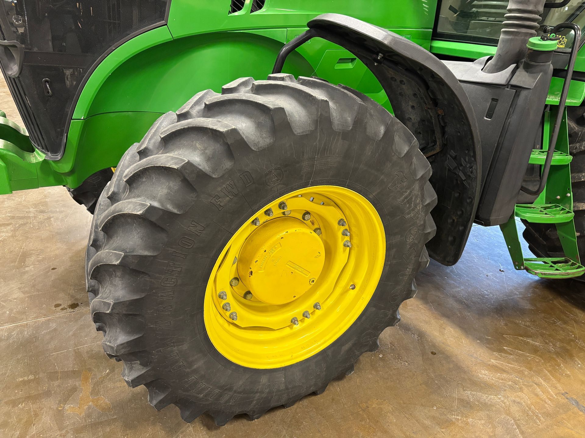 Yellow tractor wheel with black tire.