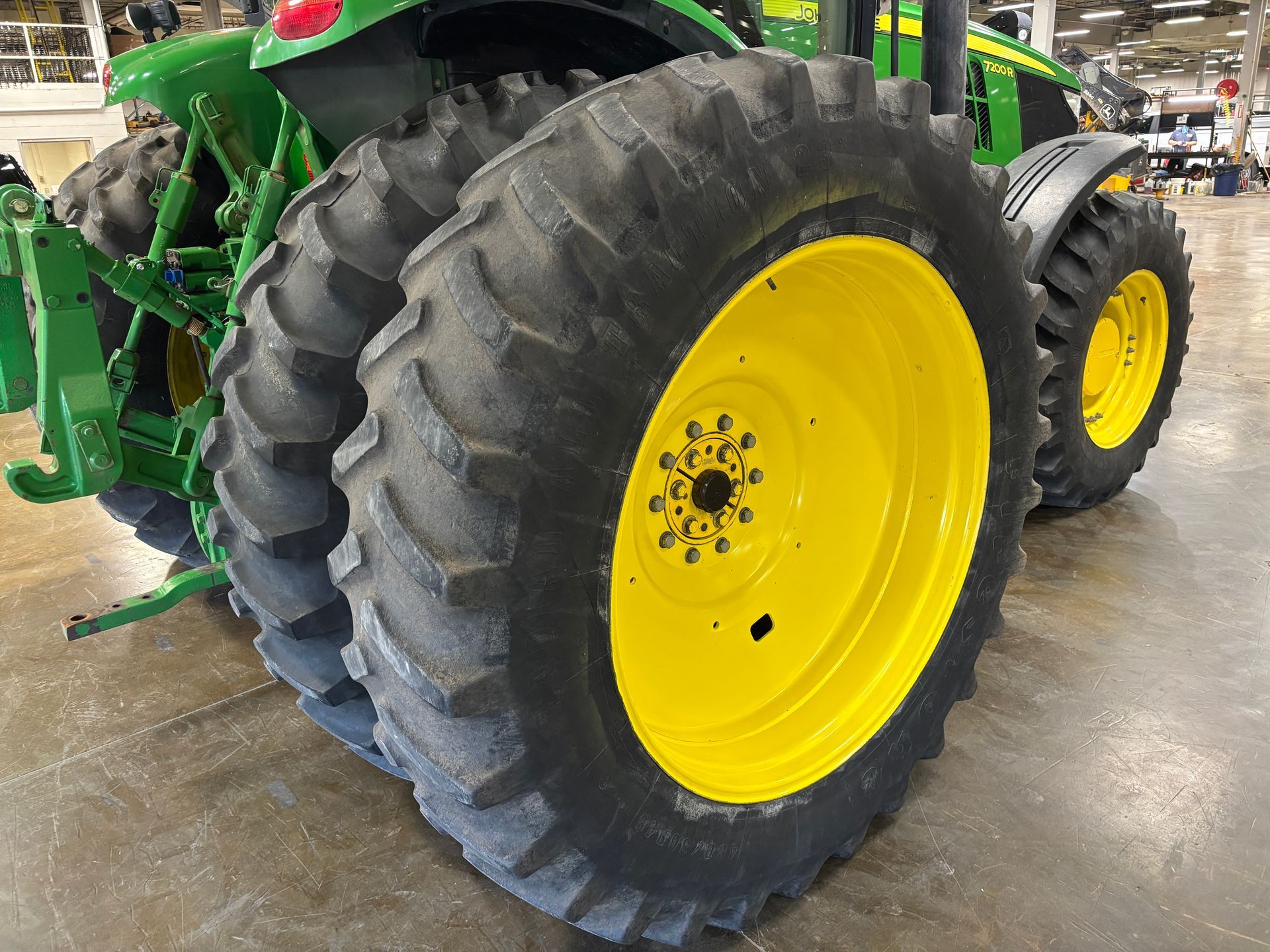Yellow John Deere tractor tire and wheel.