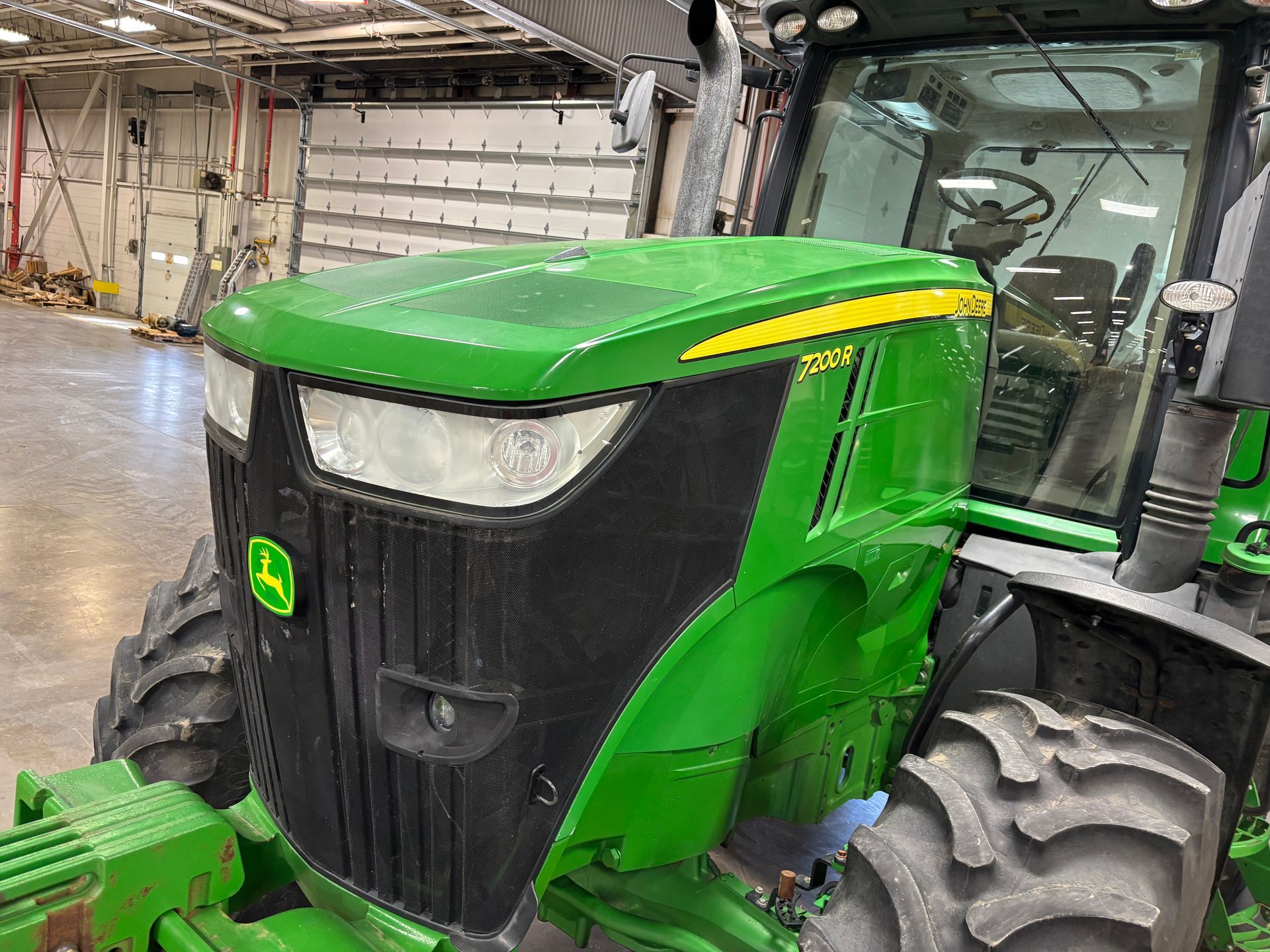Green John Deere tractor, black grill, yellow stripe.