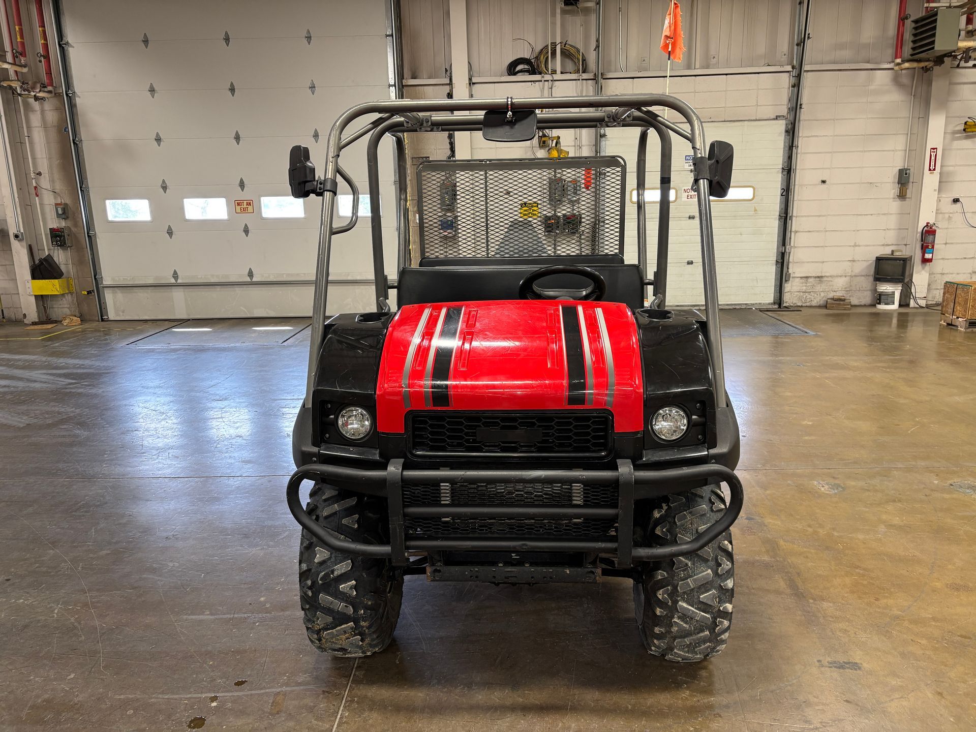 Front view of a red and black utility vehicle in a warehouse.