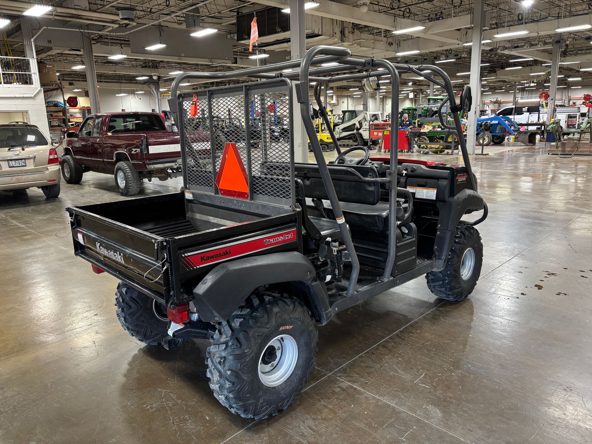 Black utility vehicle with a cargo bed inside a large showroom.