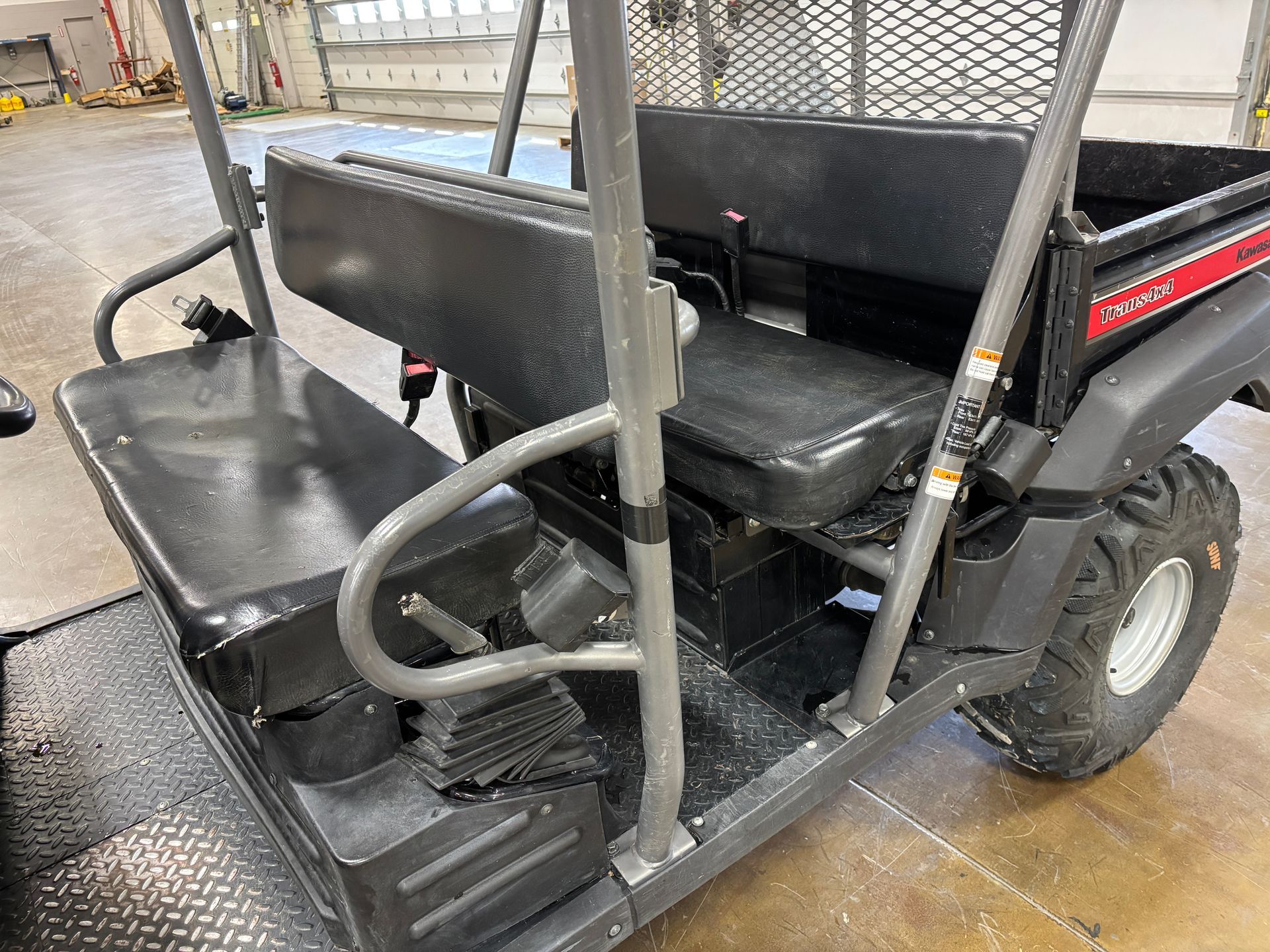 Utility vehicle, black seats, roll bar, and off-road tires.